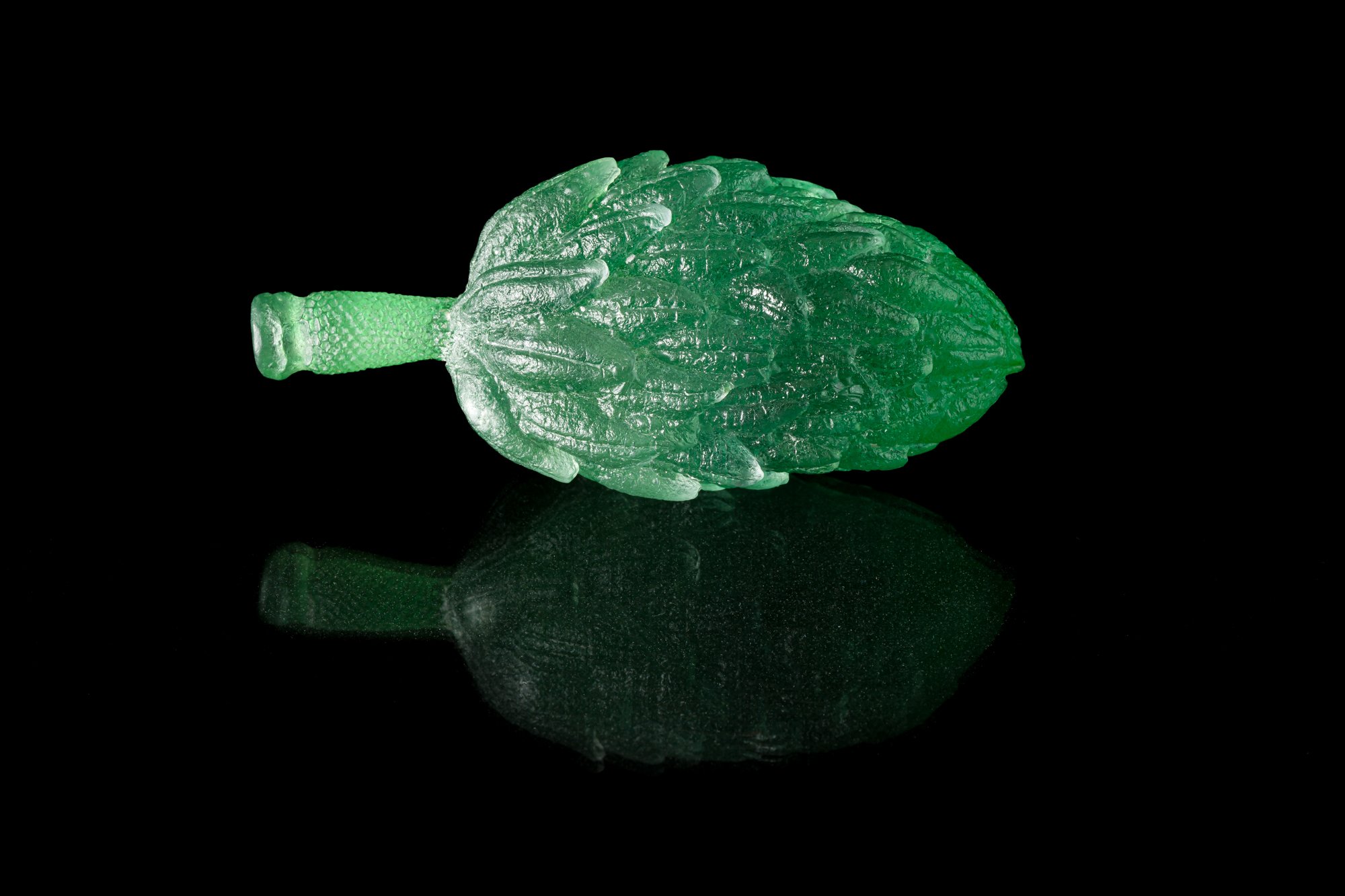 Handcrafted glass magnolia pod in green color about 3-4 inches in length.
