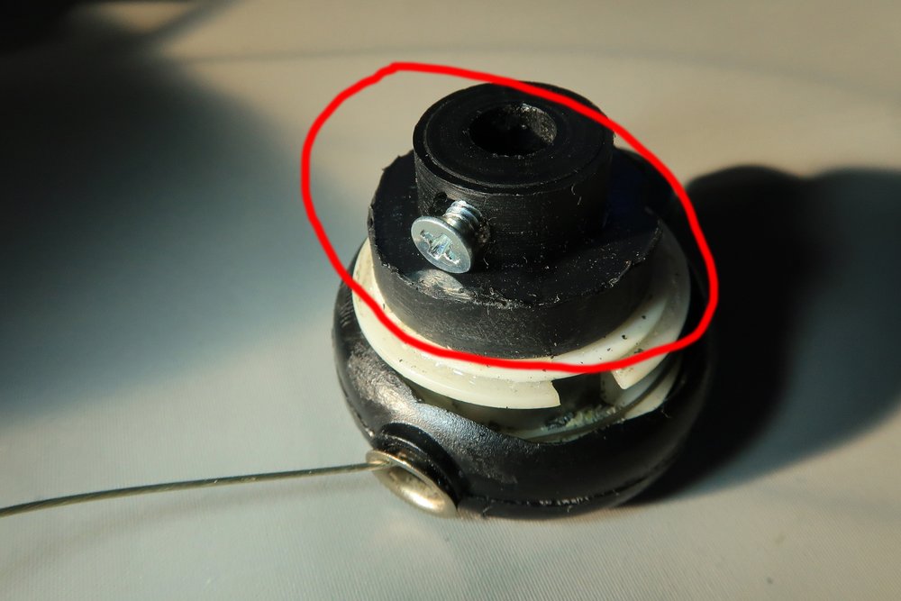  The retractable spring-loaded spool removed from the base of box.&nbsp; Note the screw which is used to secure the spool to the shaft of the potentiometer.&nbsp; Also note that the two-tiered, black-coloured cylindrical attachment (with the screw).