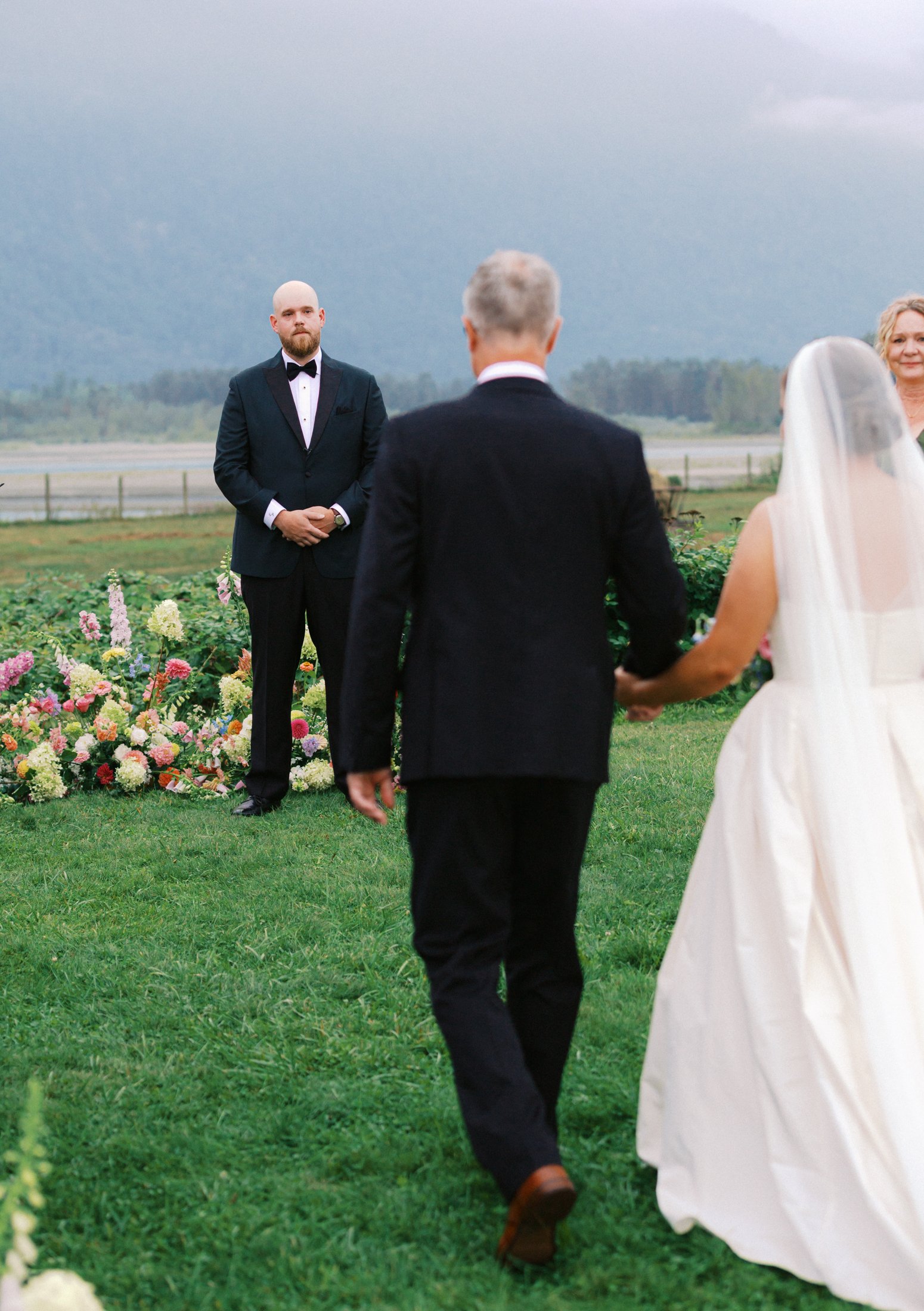 Fraser River Lodge ceremony coverage featuring emotional aisle walk, first kiss, signing the marriage license and guest reactions, captured with documentary storytelling on digital and 35mm film.