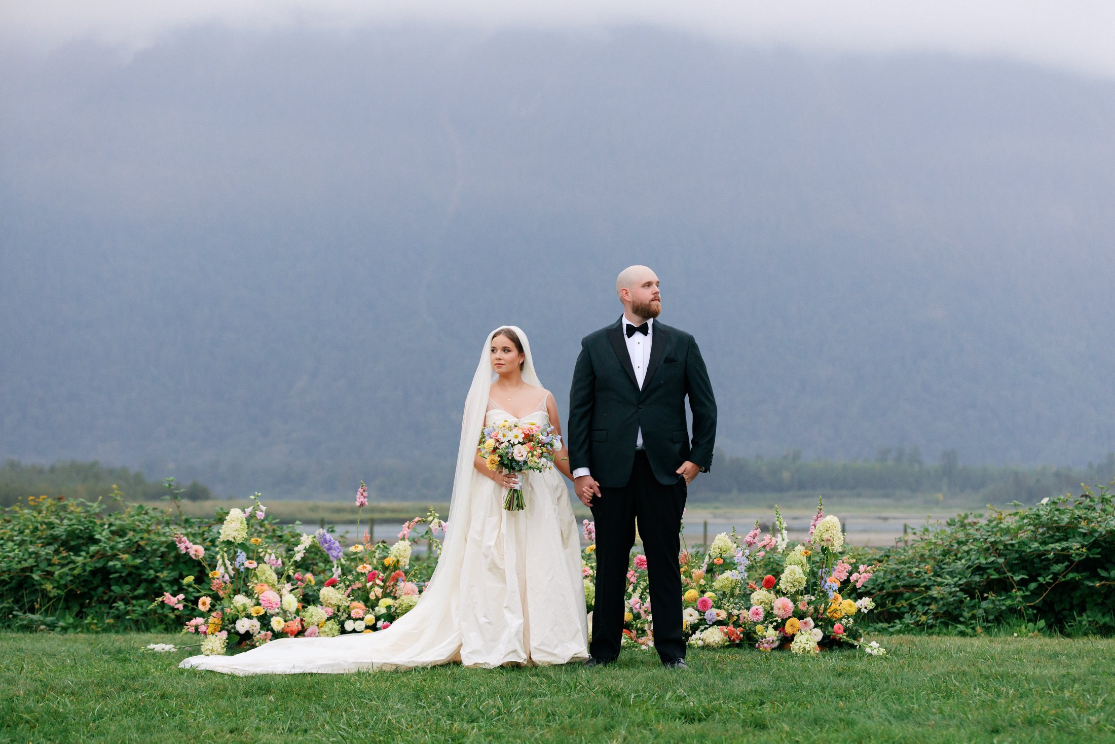 Editorial outdoor wedding portraits at Fraser River Lodge by the ceremony floral arrangement with mountain views, photographed on film + digital by Julia Hindy Photography.