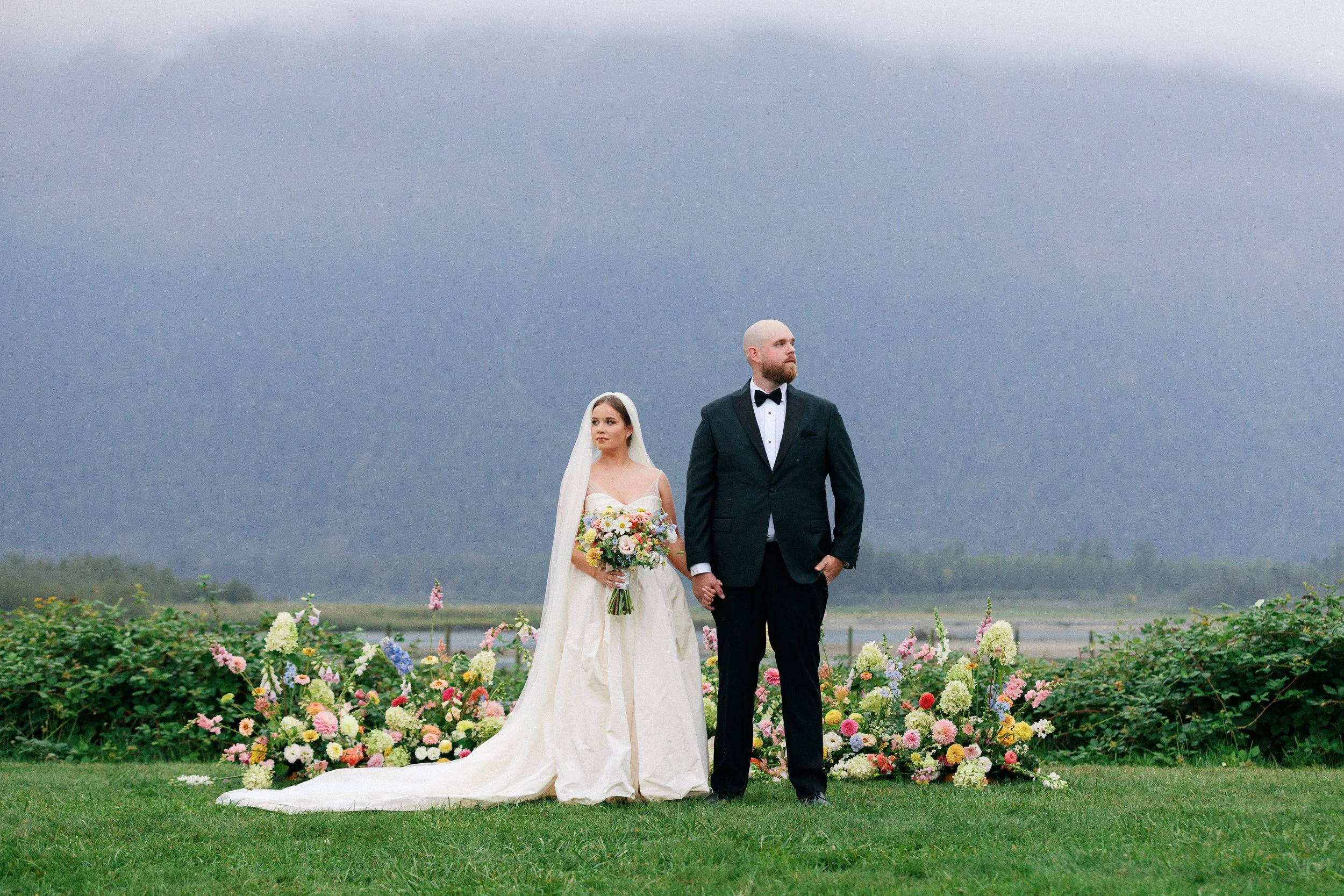 Couple posed in front of flower arch at Fraser River Lodge after their wedding ceremony