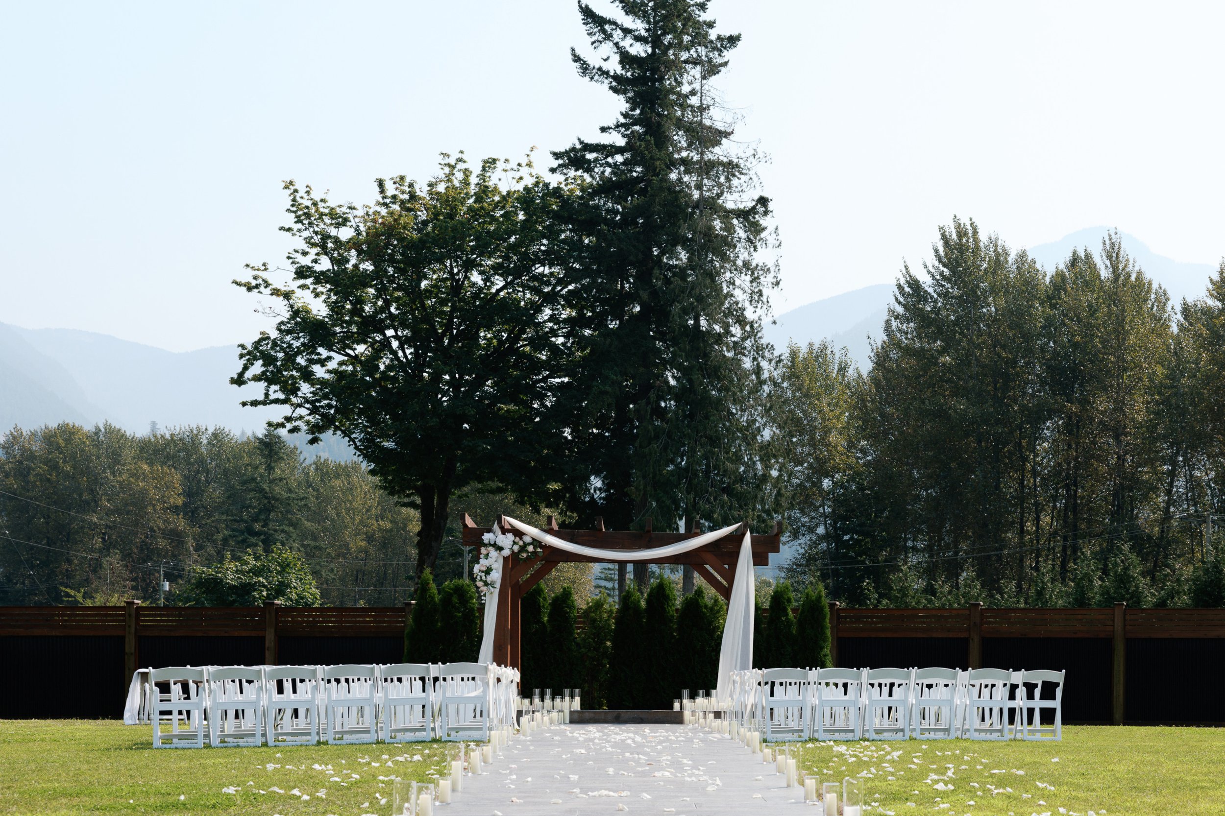 Scenic exterior of a Fraser Valley wedding venue featuring open landscapes, elegant ceremony seating, and guests gathering before the ceremony.