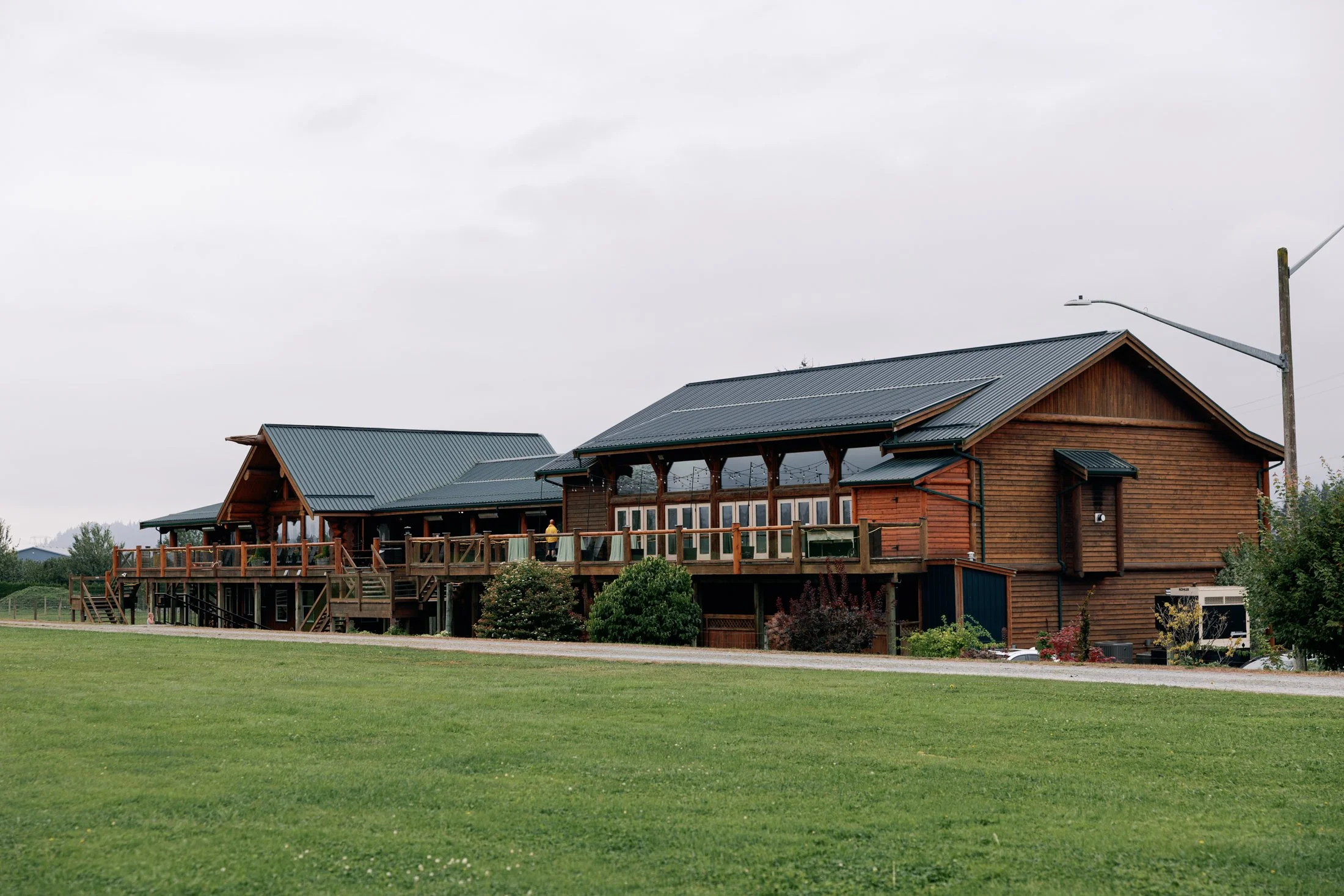 Peaceful pre-ceremony wedding ceremony layout at Fraser River Lodge — floral arrangement and ceremony chairs facing the mountains on the grass, photographed in an authentic documentary style using digital + film.