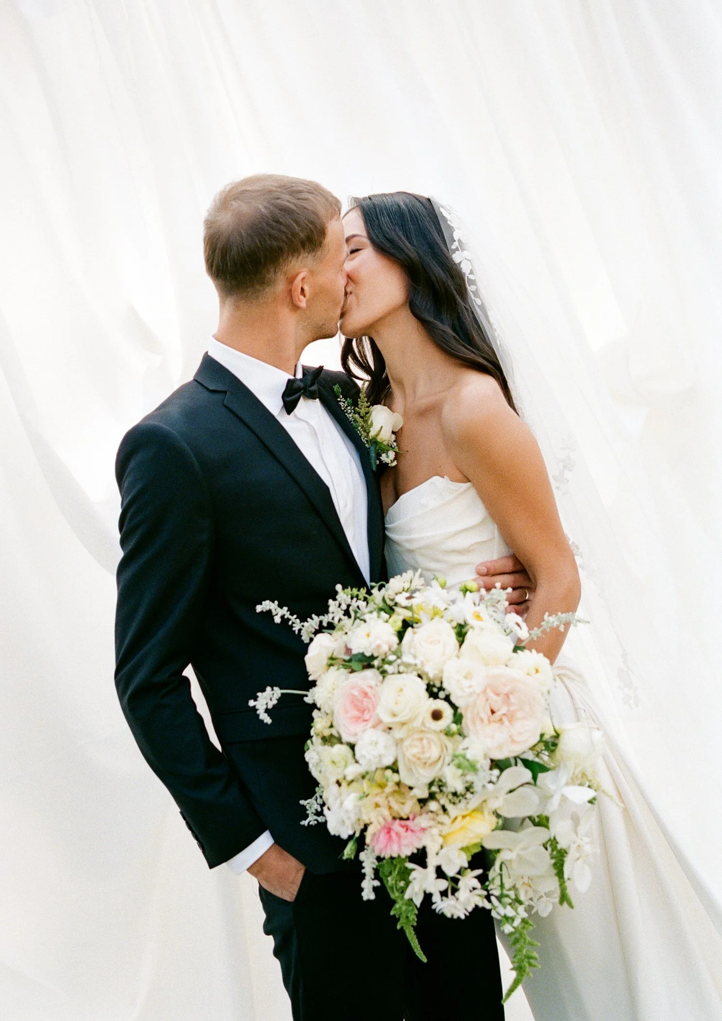 Bride and bridal party portraits photographed in front of custom white drapery ceremony backdrop at modern luxury backyard wedding in Langley BC