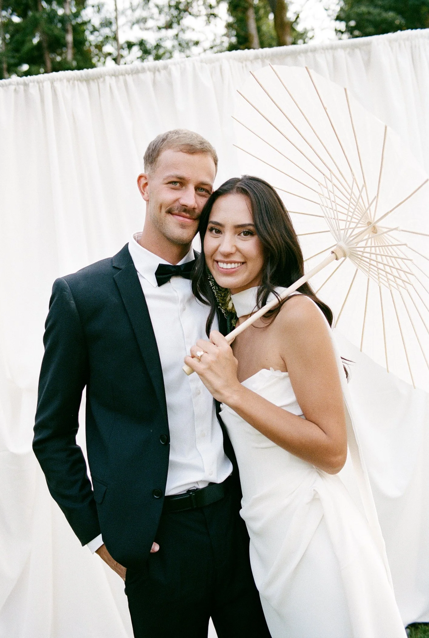 Bride and bridesmaids portraits in front of elegant draped backdrop at modern luxury backyard wedding in Langley BC