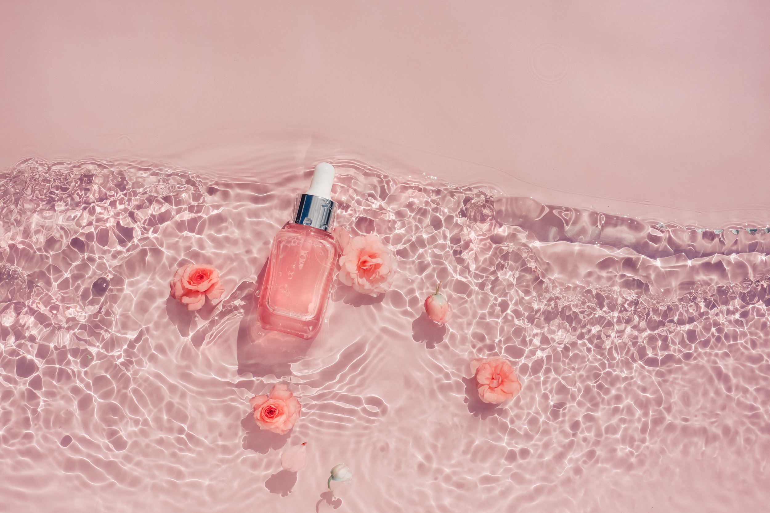 transparent-pink-bottle-of-serum-in-water-with-flo-2023-11-27-05-28-31-utc.jpg