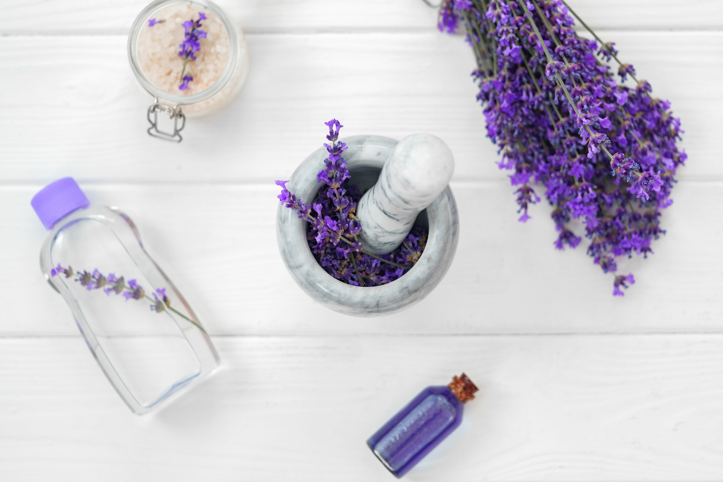 herbal-oil-and-lavender-flowers-on-white-wooden-ba-2023-11-27-05-36-13-utc.jpg