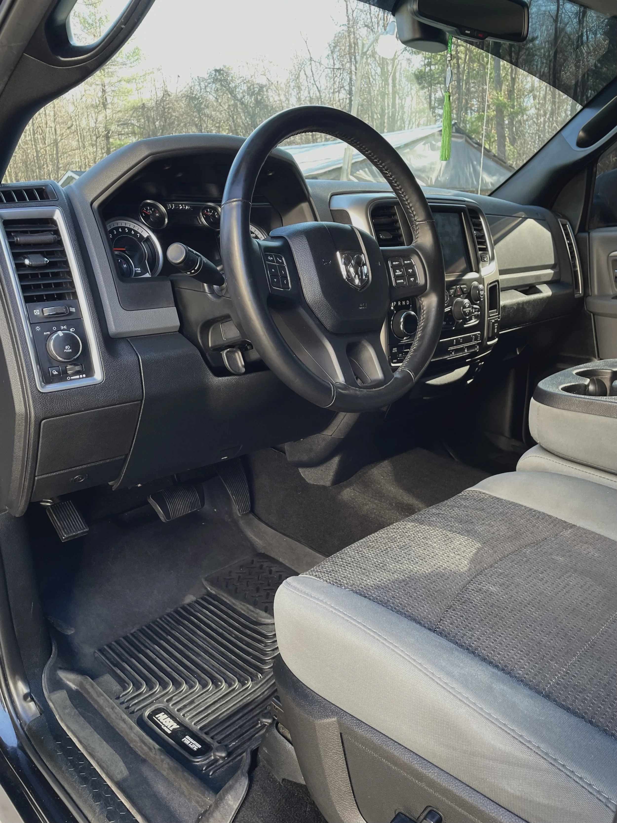 Interior of a truck, showing the dashboard, steering wheel, and front seat.