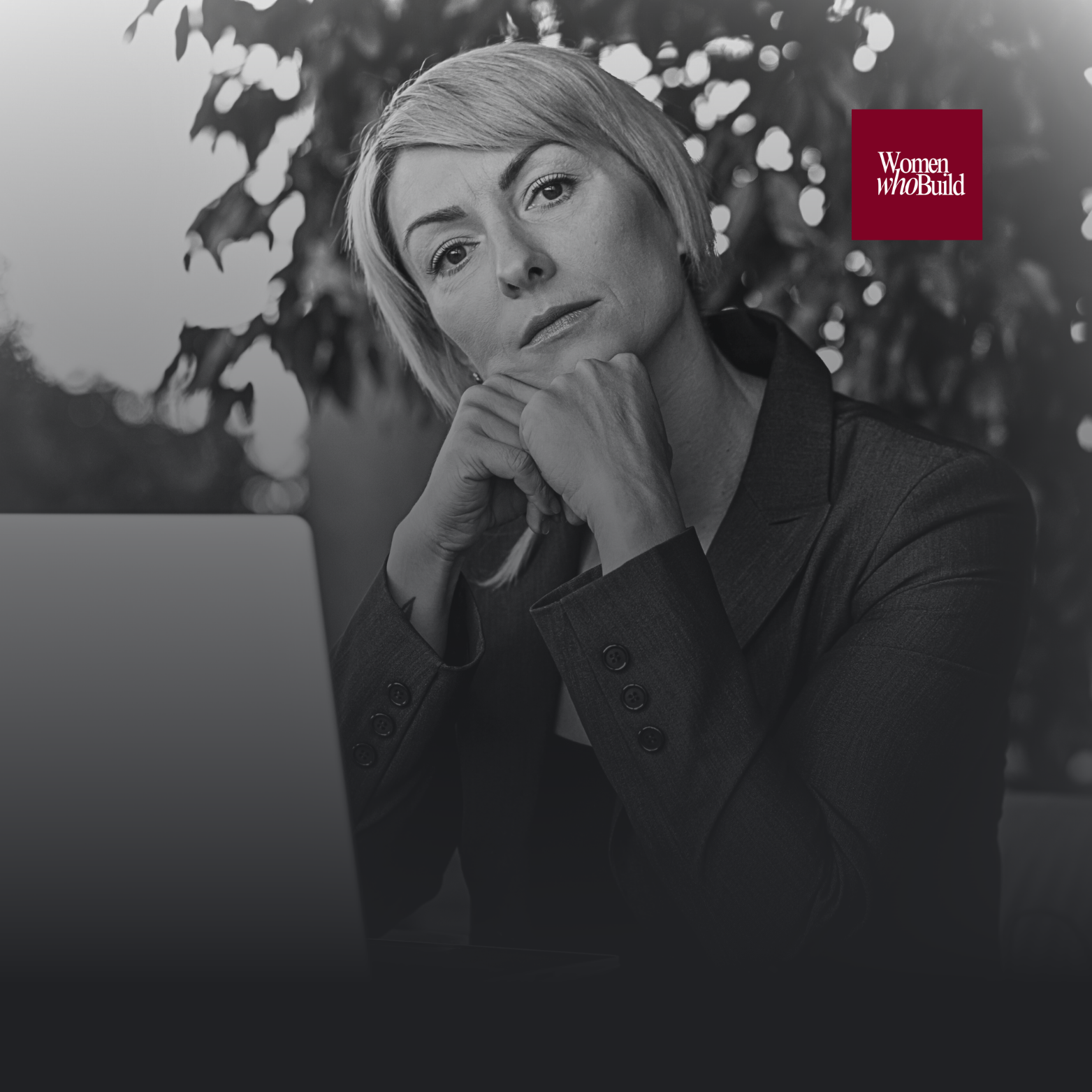 Black-and-white image of a thoughtful professional woman sitting at a desk leadership, resilience,  cover image for Rezan Manan’s article ‘Midlife, Menopause In The Boardroom: Leading Through Your Strongest, Most Challenging Years’ on rezanmanan.com