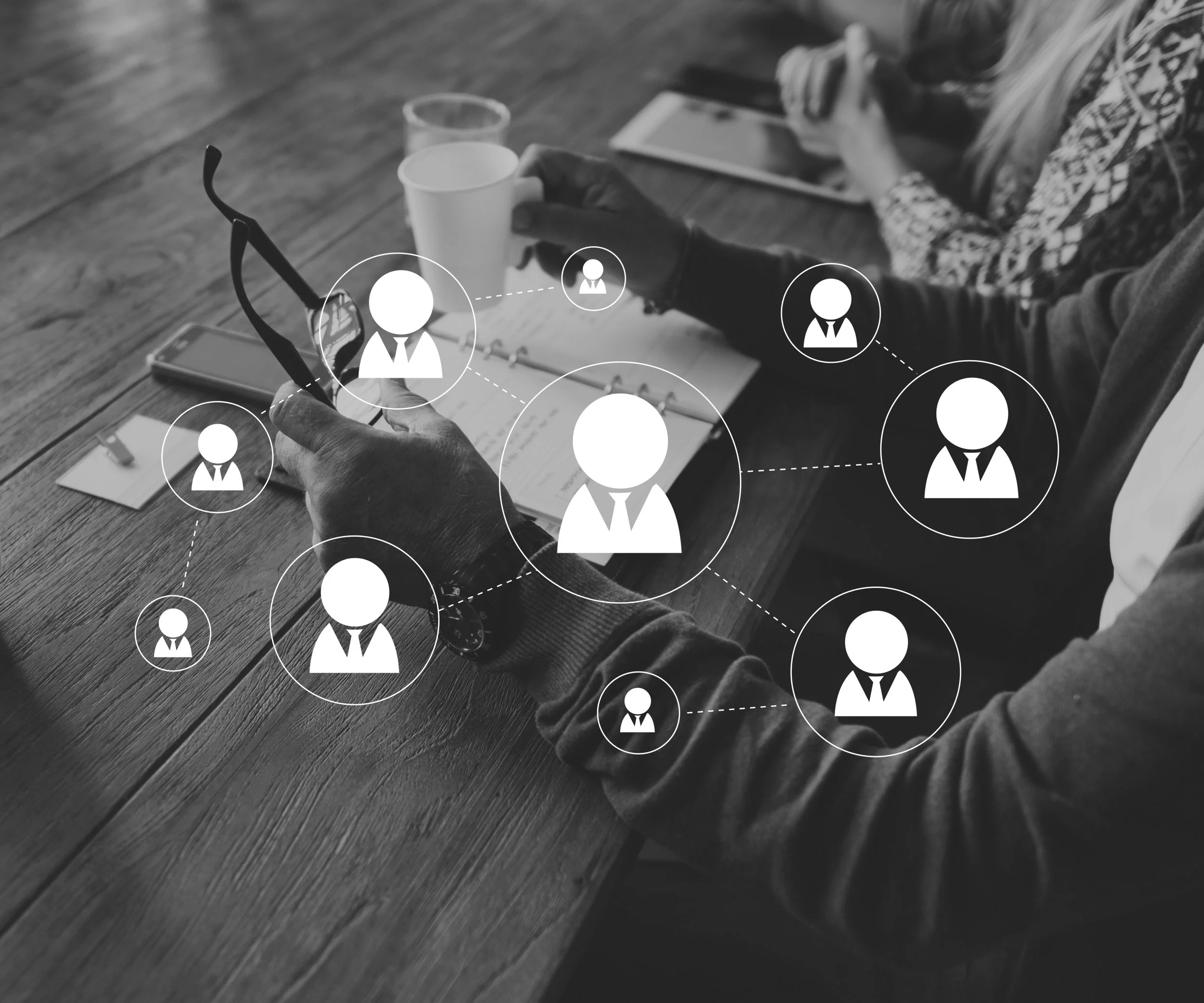 Business meeting with people engaged in networking, with icons representing people connected in a social network overlay.