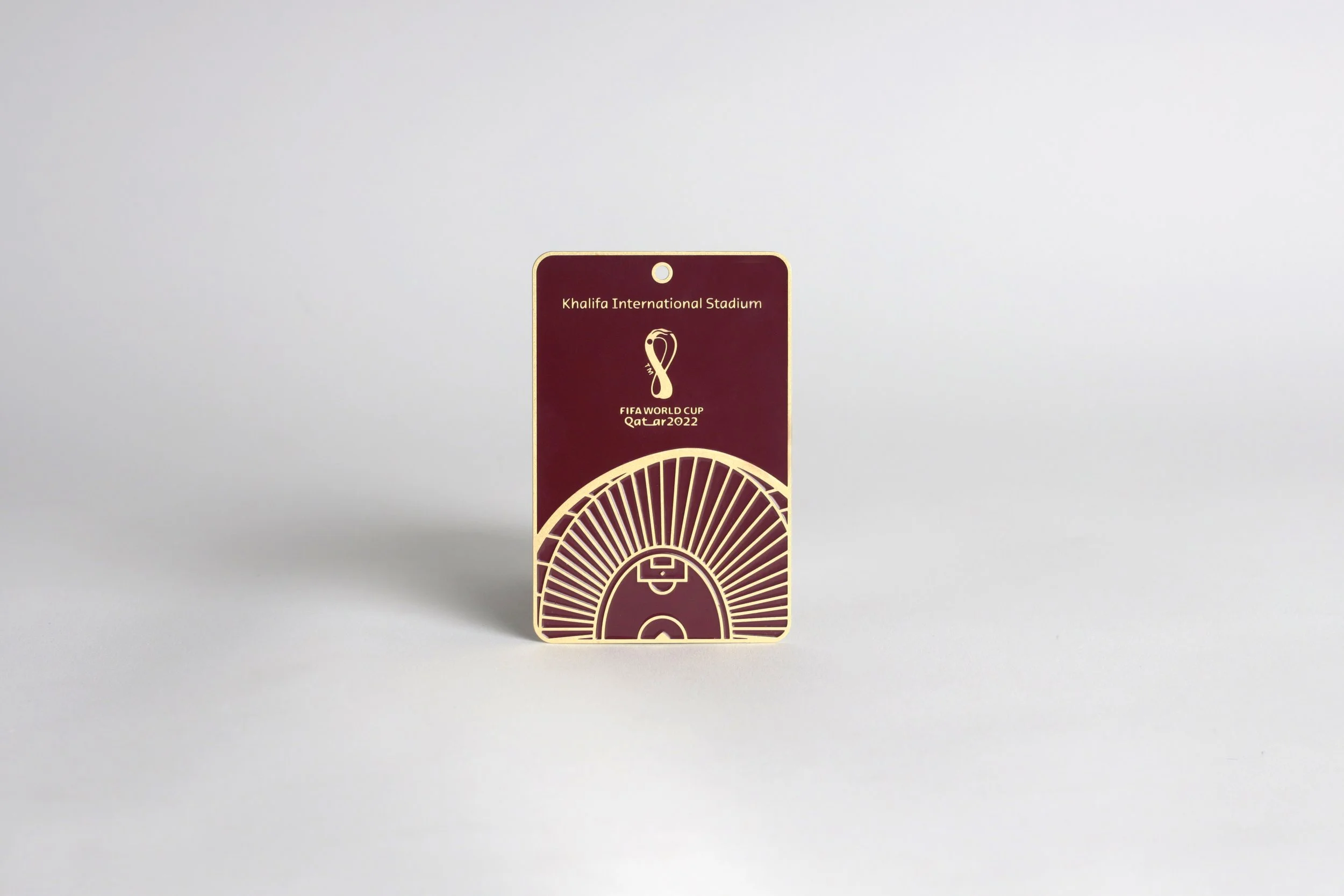 A maroon and gold card with the text 'Khalifa International Stadium' and the FIFA World Cup Qatar 2022 logo, standing upright against a plain white background.