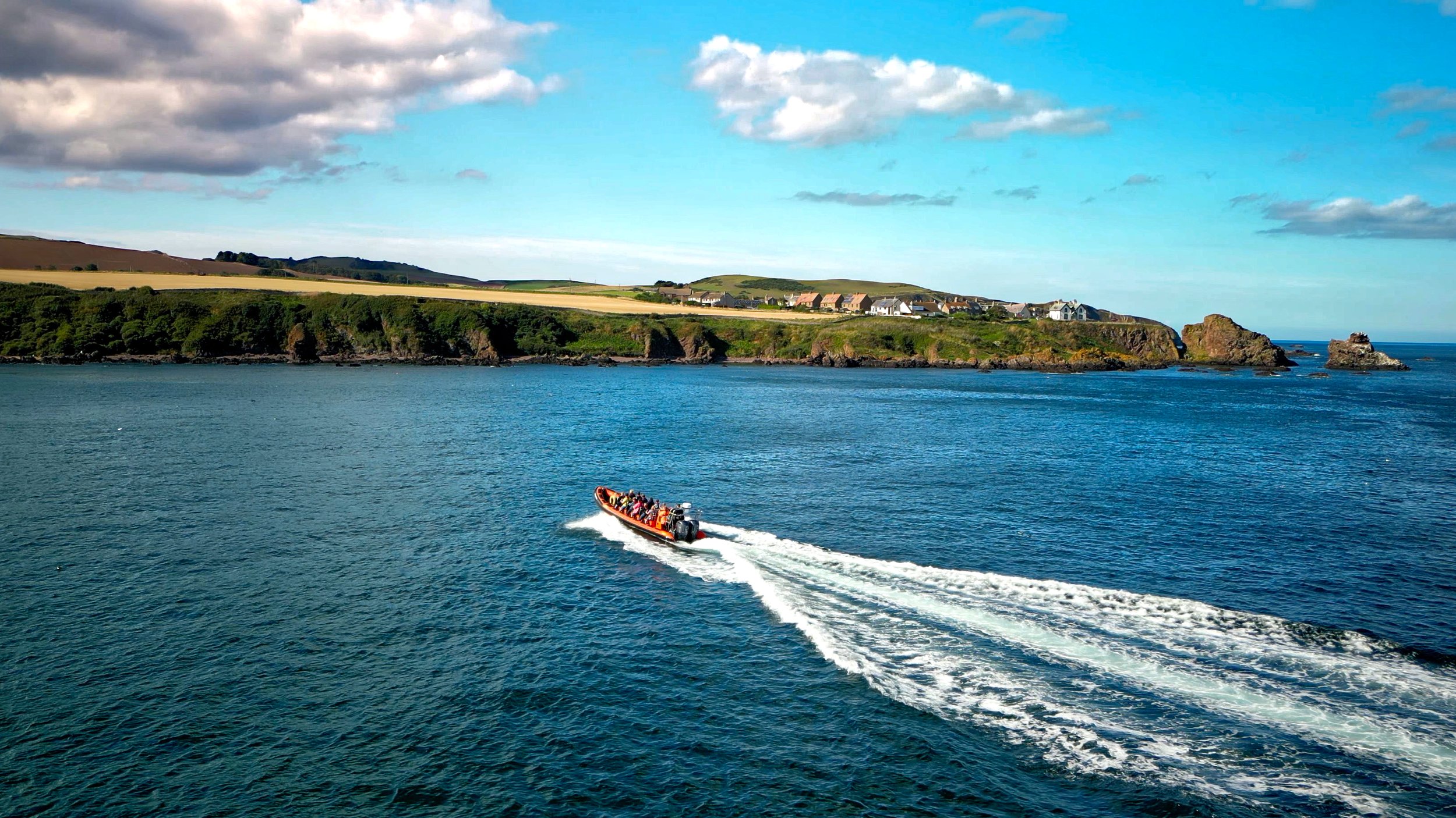 The RIB with cliffs in the background