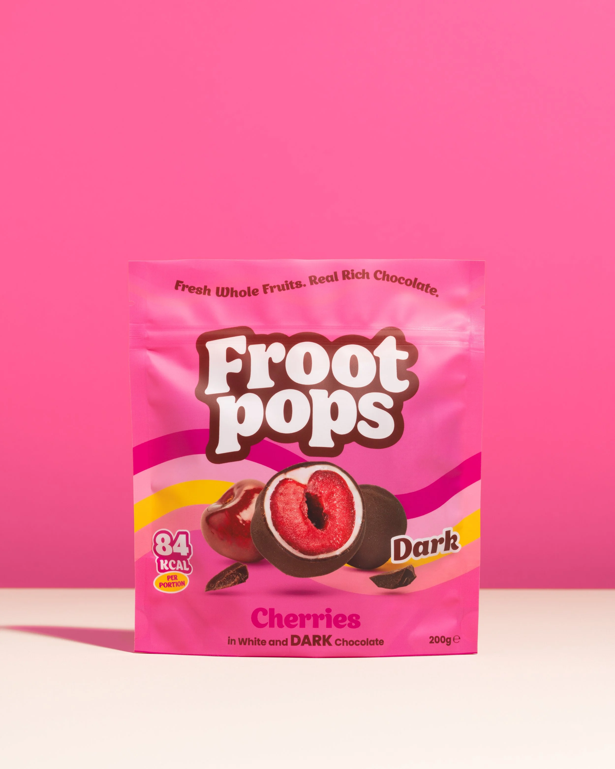 Pink package of Frozen Fruit Pops with cherries flavor. The packaging features an image of cherries and chocolate-dipped cherry pops on a white background.