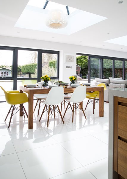 white-open-plan-bright-kitchen-bifold-doors