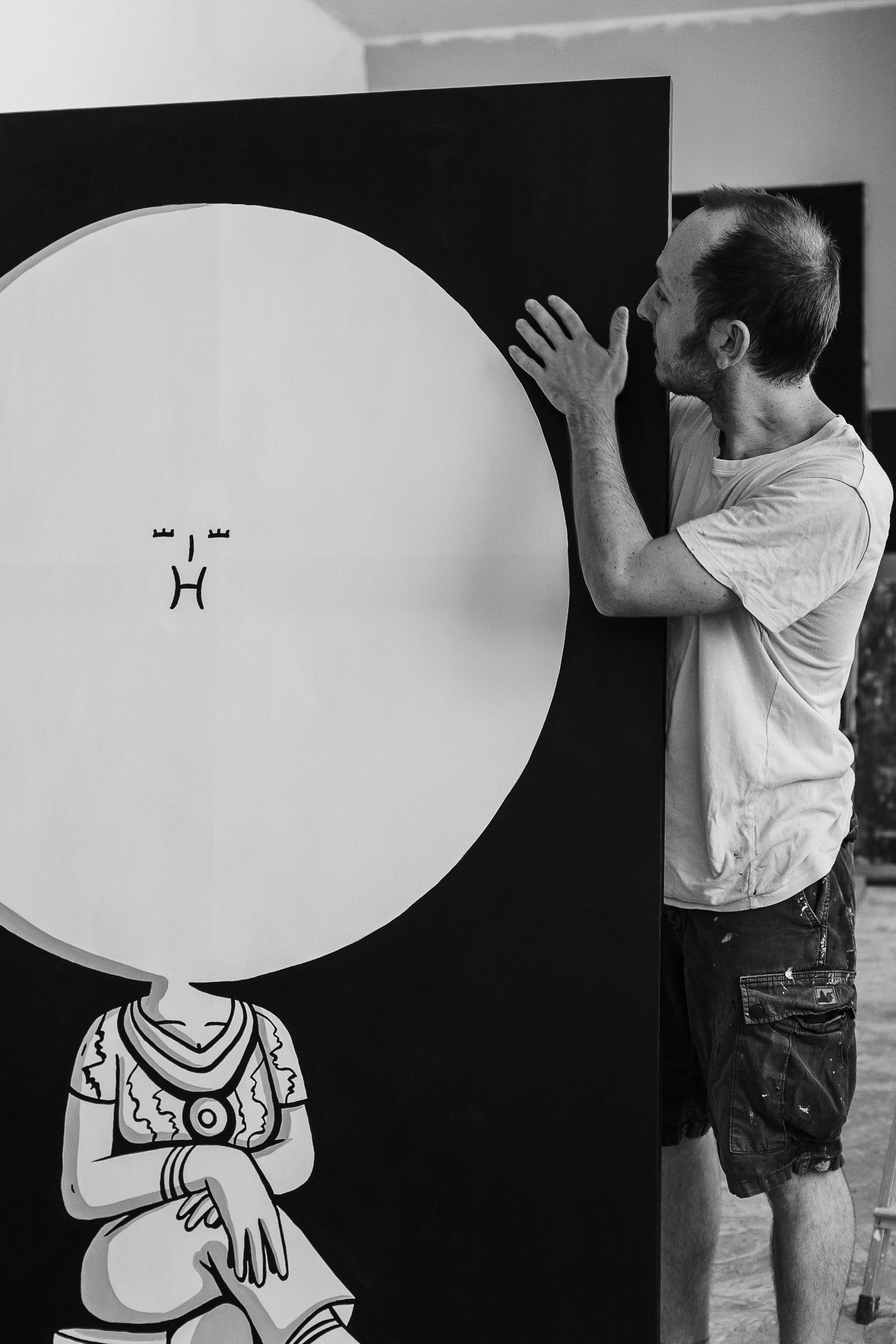 Un uomo che osserva un pannello con un'illustrazione di una persona seduta, disegnata in stile minimalista.