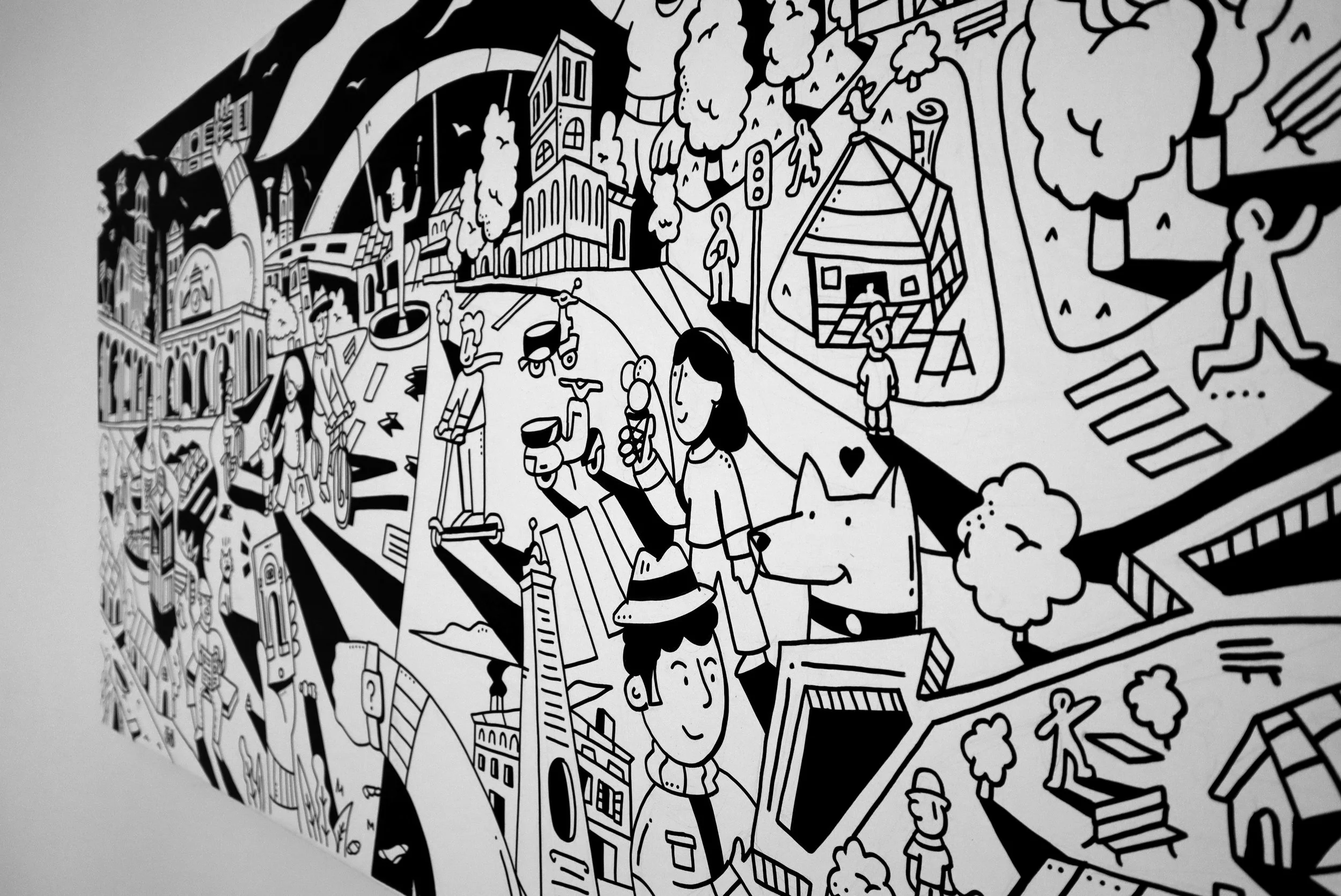Disegno in bianco e nero di una città con edifici, alberi, persone che camminano, biciclette e altri elementi urbani in stile cartoon o disegno lineare.