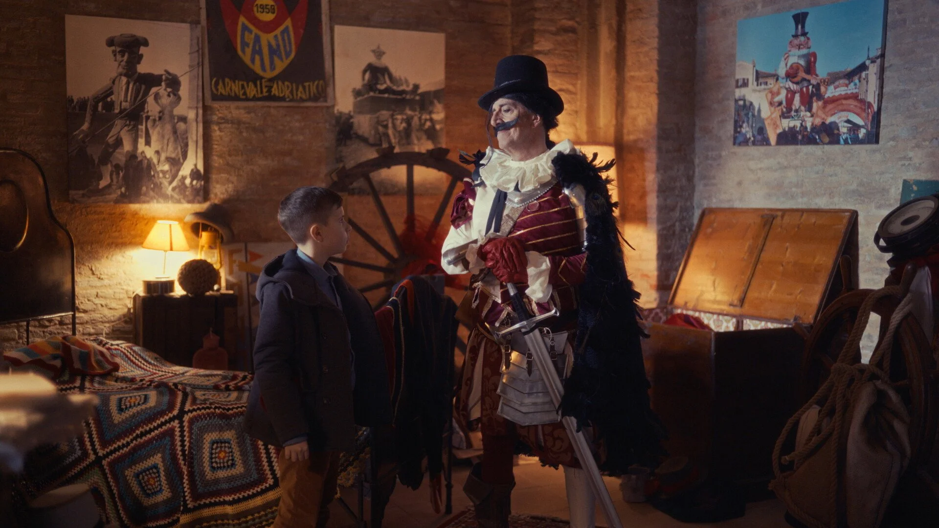 A person dressed as a historical soldier in armor and holding a sword, talking to a young boy in a cozy room with vintage posters and rustic decor.