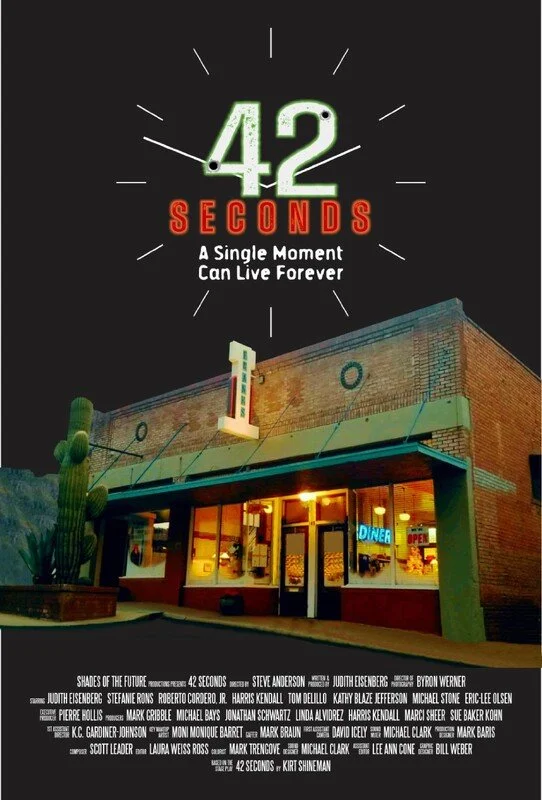 The cover of the book titled '42 Seconds: A Single Moment Can Live Forever' features a night scene of a restaurant with a neon 'Diner' sign, a tall cactus on the left, and a partly illuminated brick building. The title '42 Seconds' is prominently displayed at the top with a clock graphic around it.