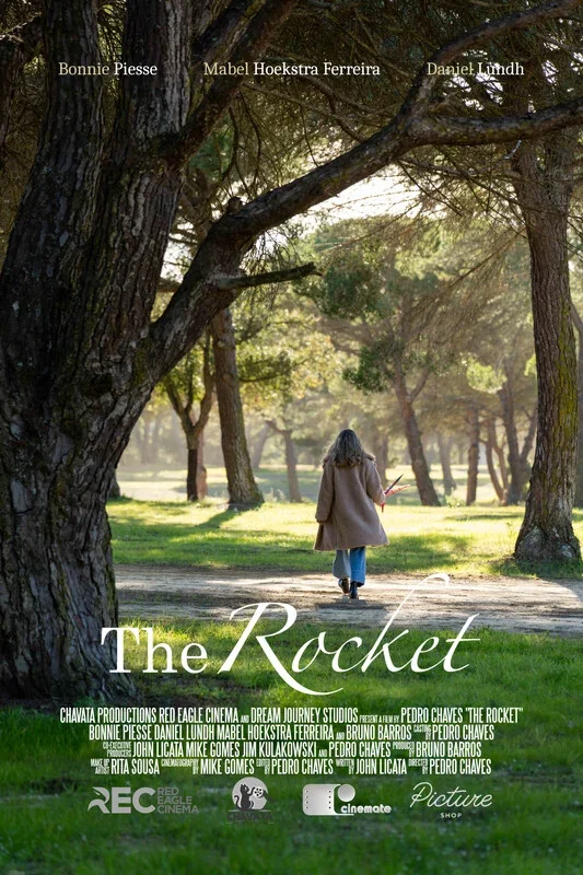 A woman walking away in a park with large trees and sunlight, holding a phone. The film title is "The Rocket" with credits for producers and director, and the names Bonnie Piesse, Mabel Hoekstra Ferreira, and Daniel Lundh are listed at the top.