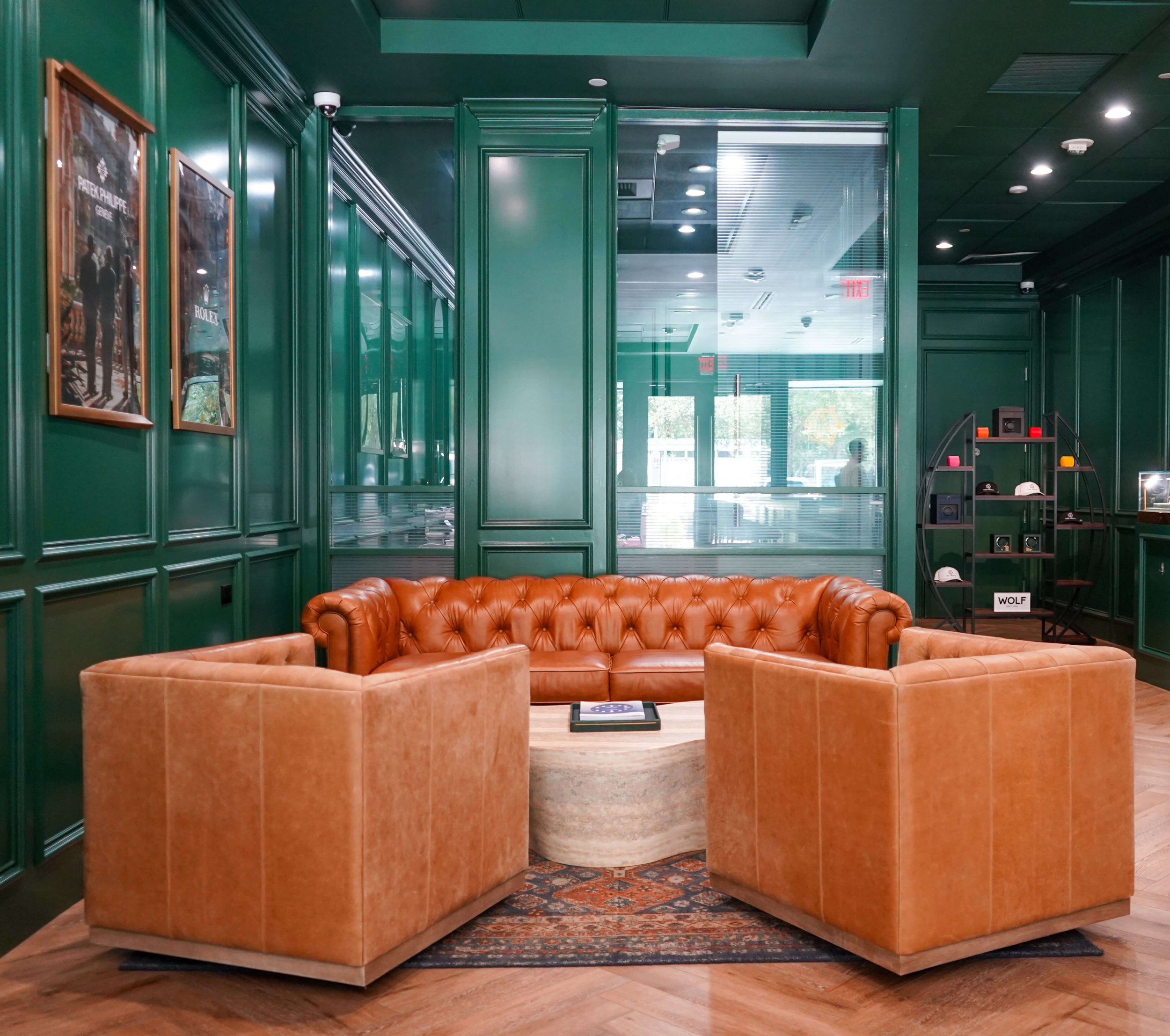 Lounge seating area with Rolex and Patek Philippe artwork at The Crown Houston