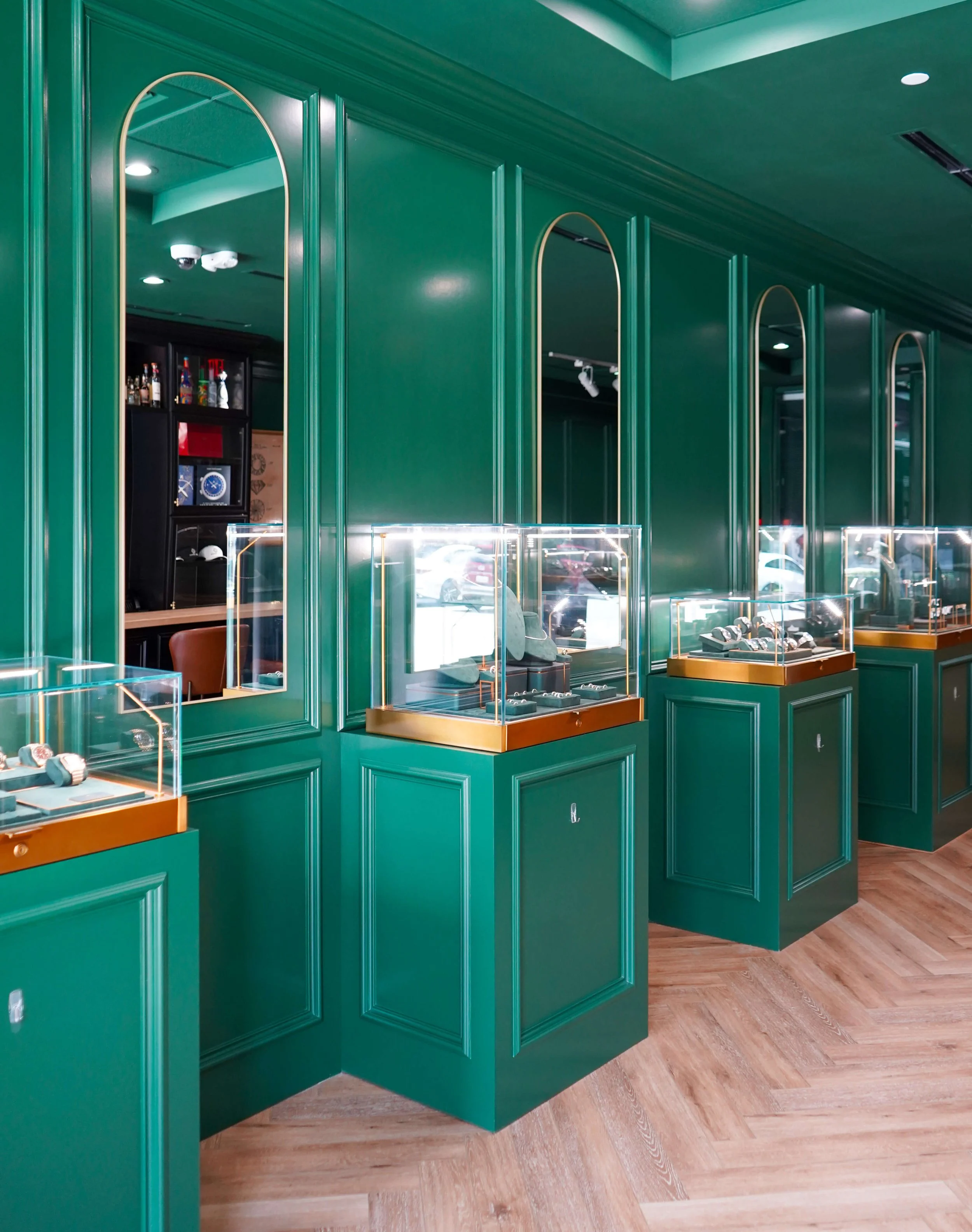 Jewelry display cases along the green paneled wall at The Crown Houston
