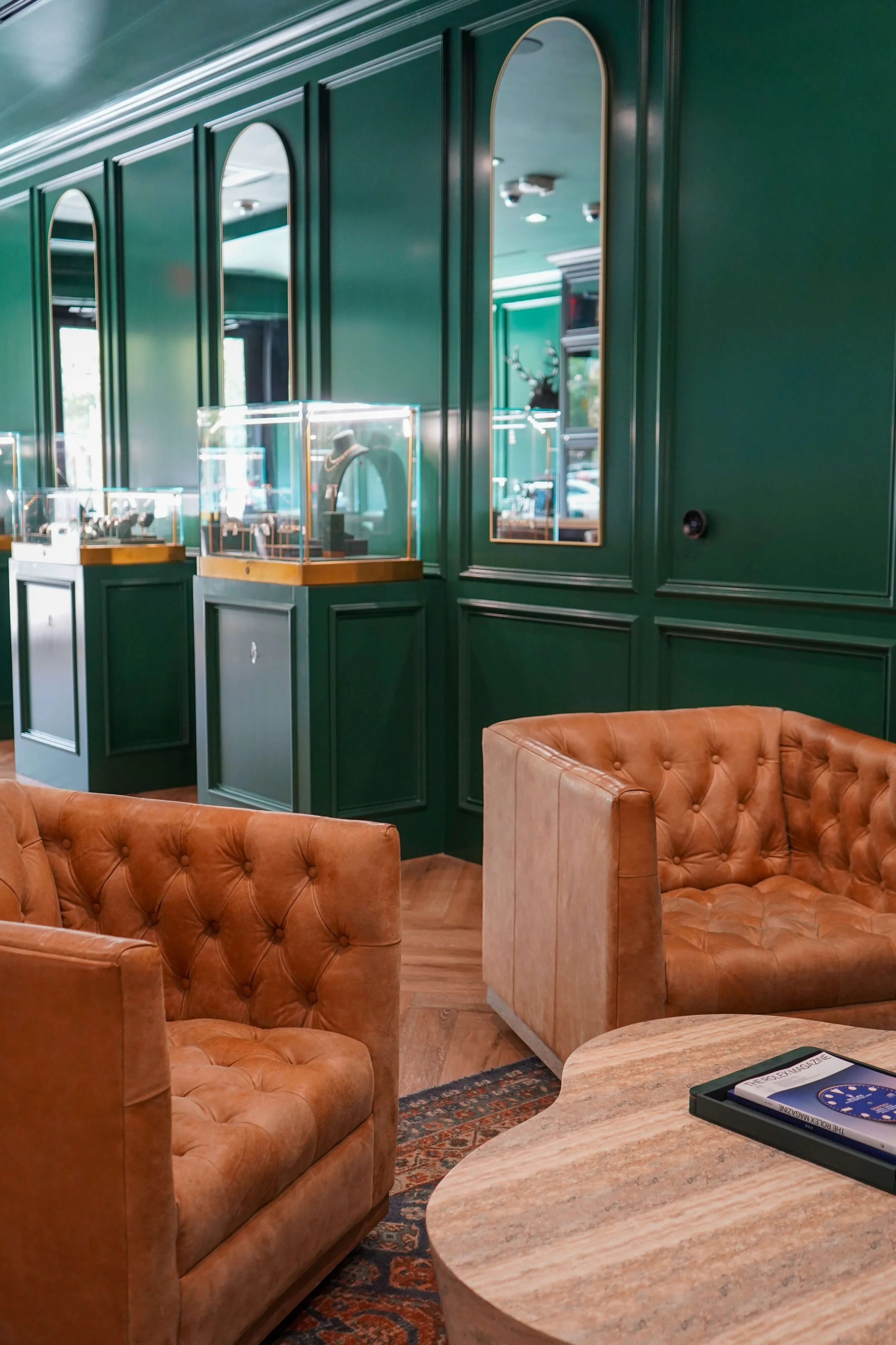 Leather lounge chairs beside jewelry display cases at The Crown Houston