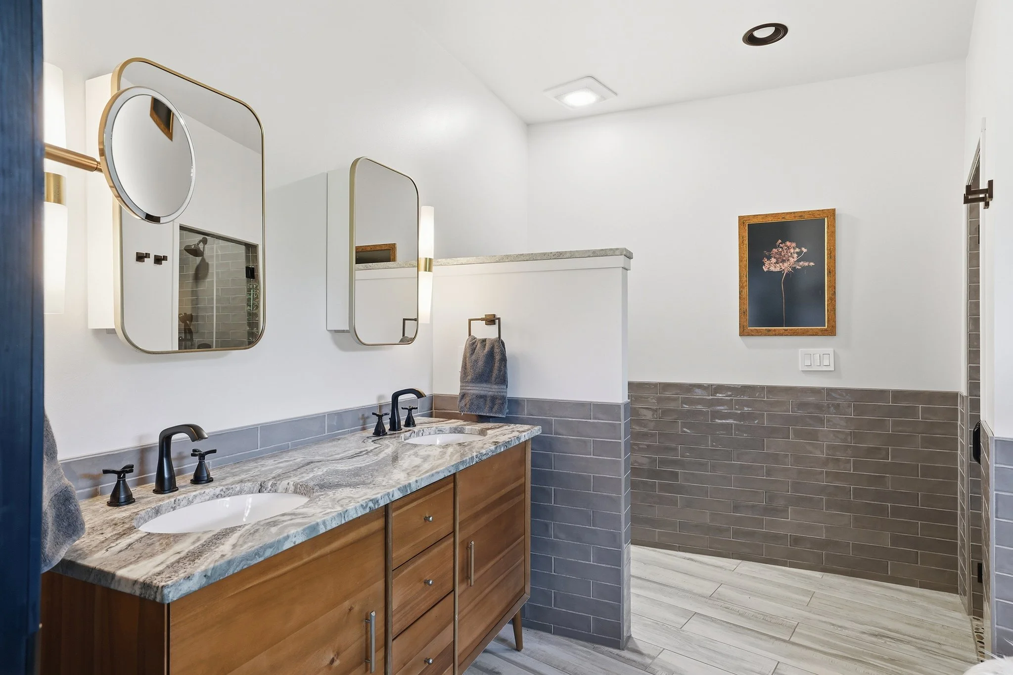 Enjoy the custom double vanity with granite top and matching brass medicine cabinets