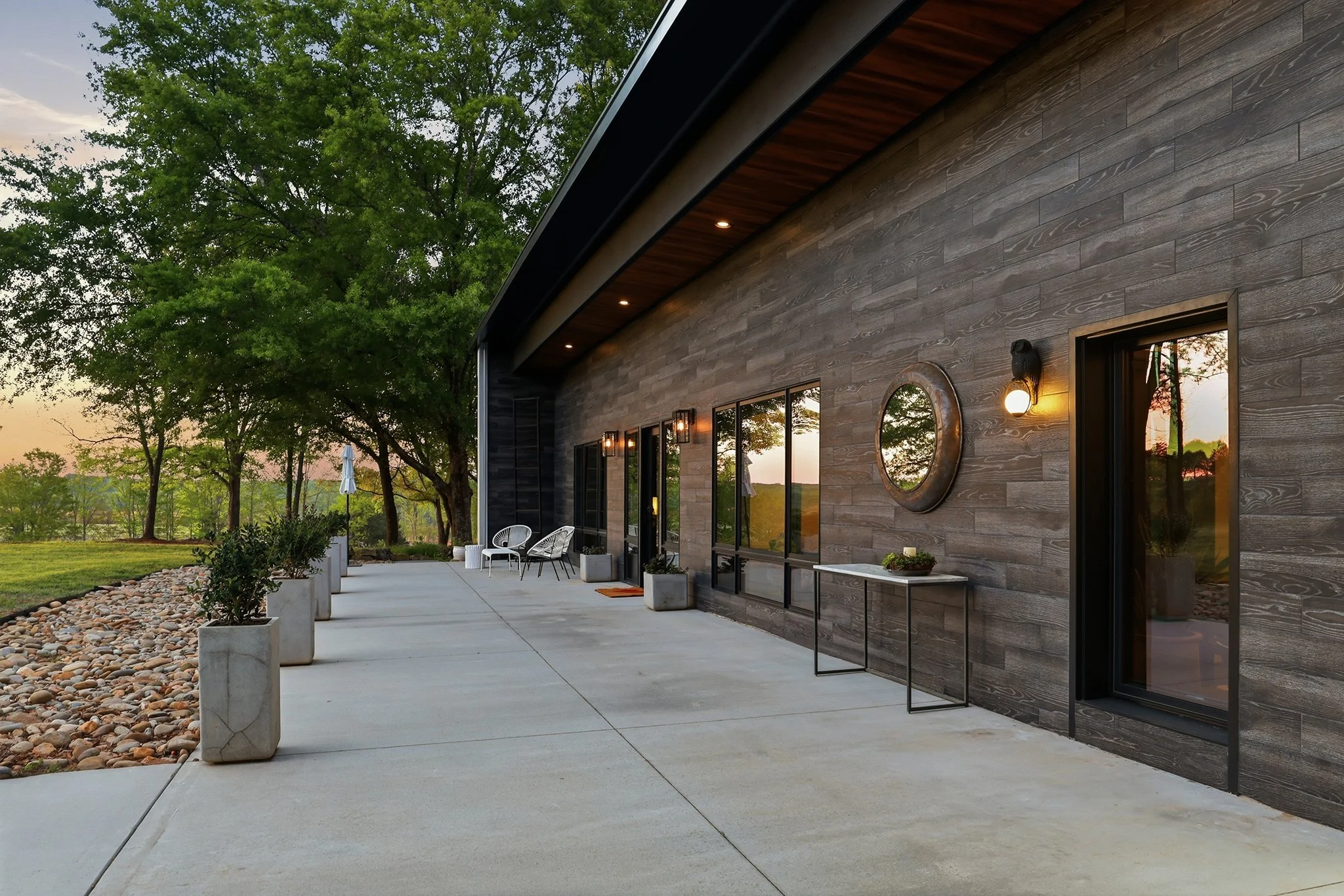 Late afternoon view of the front patio with recessed soffit lighting and sleek, elegant low maintenance tile fascia 