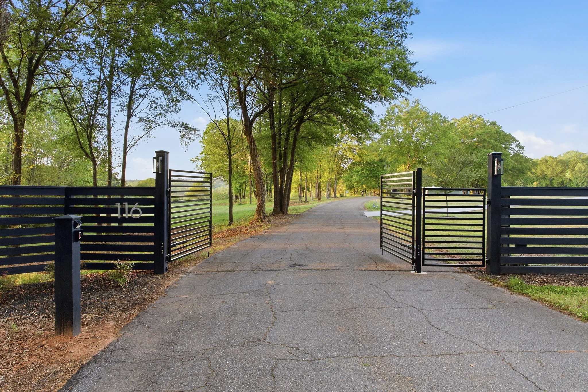 Arrive at the property through the elegant iron dual-swing electric gate with a separate pedestrian gate