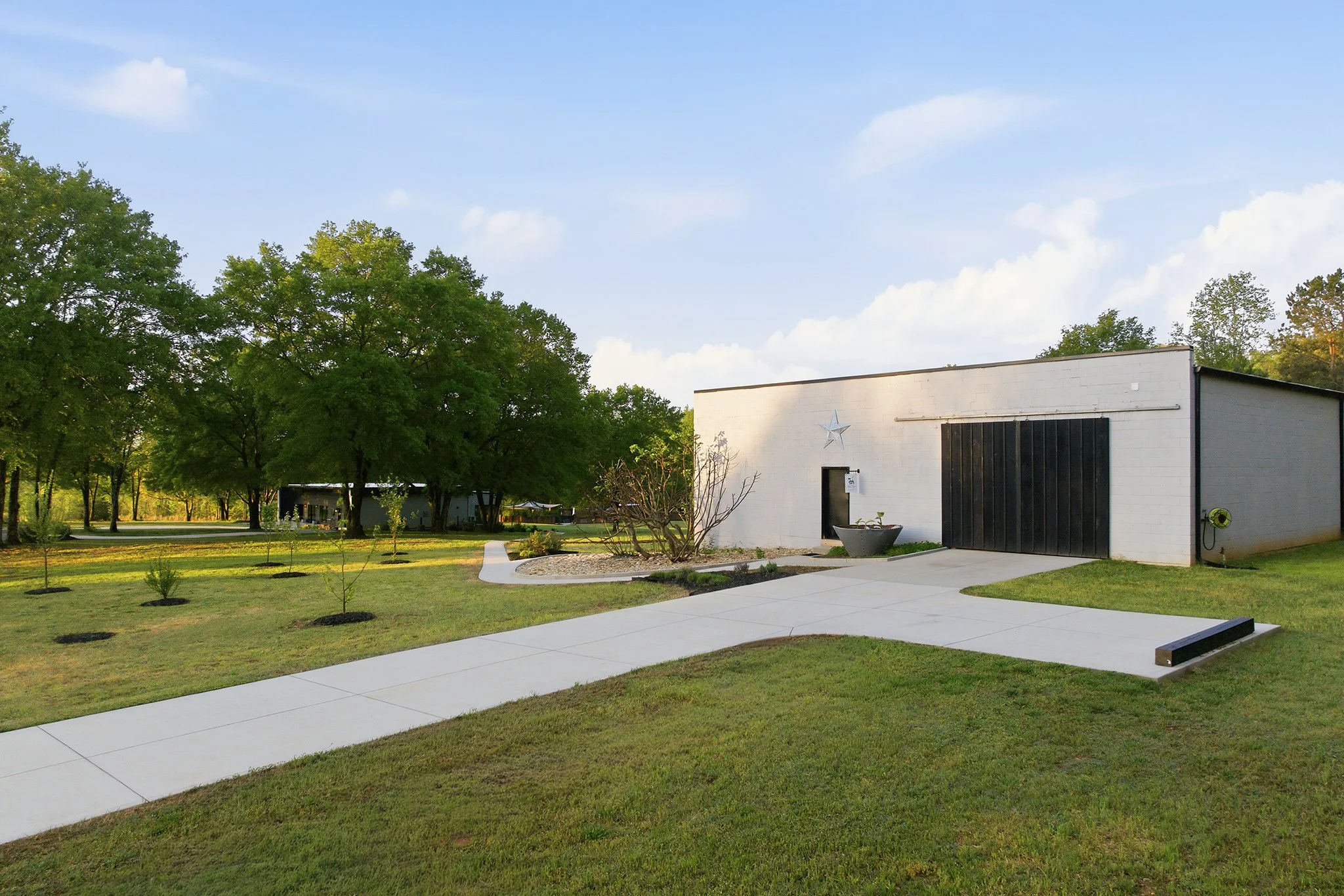 A graceful driveway entrance opens to the warehouse, where a welcoming sidewalk leads you gently to the home