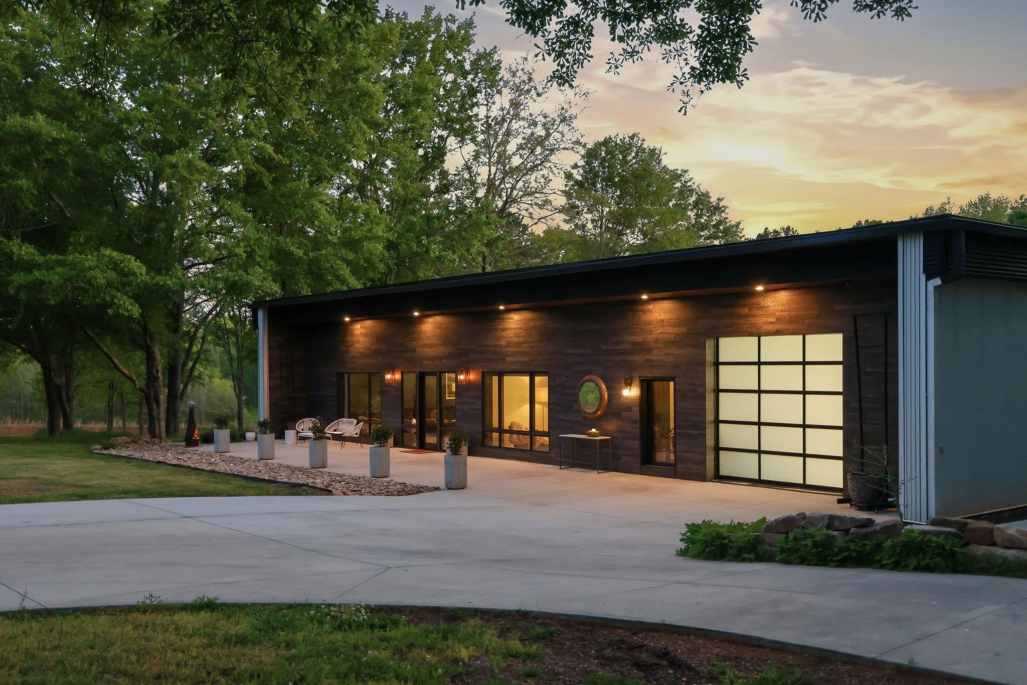 Golden twilight view of the front of the home from the driveway’s center lawn