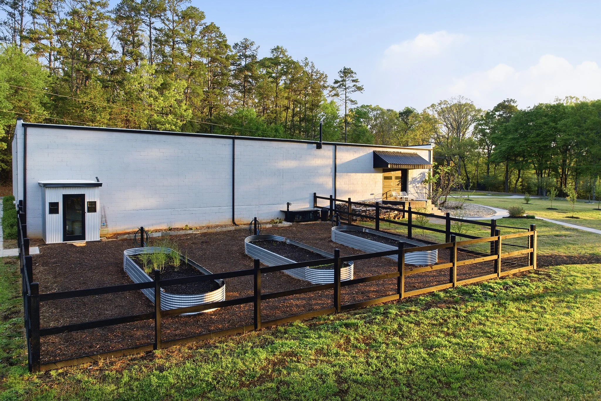 The expansive 3,000 sq ft gated garden features thoughtfully designed raised beds, creating a serene, productive oasis tucked within the property