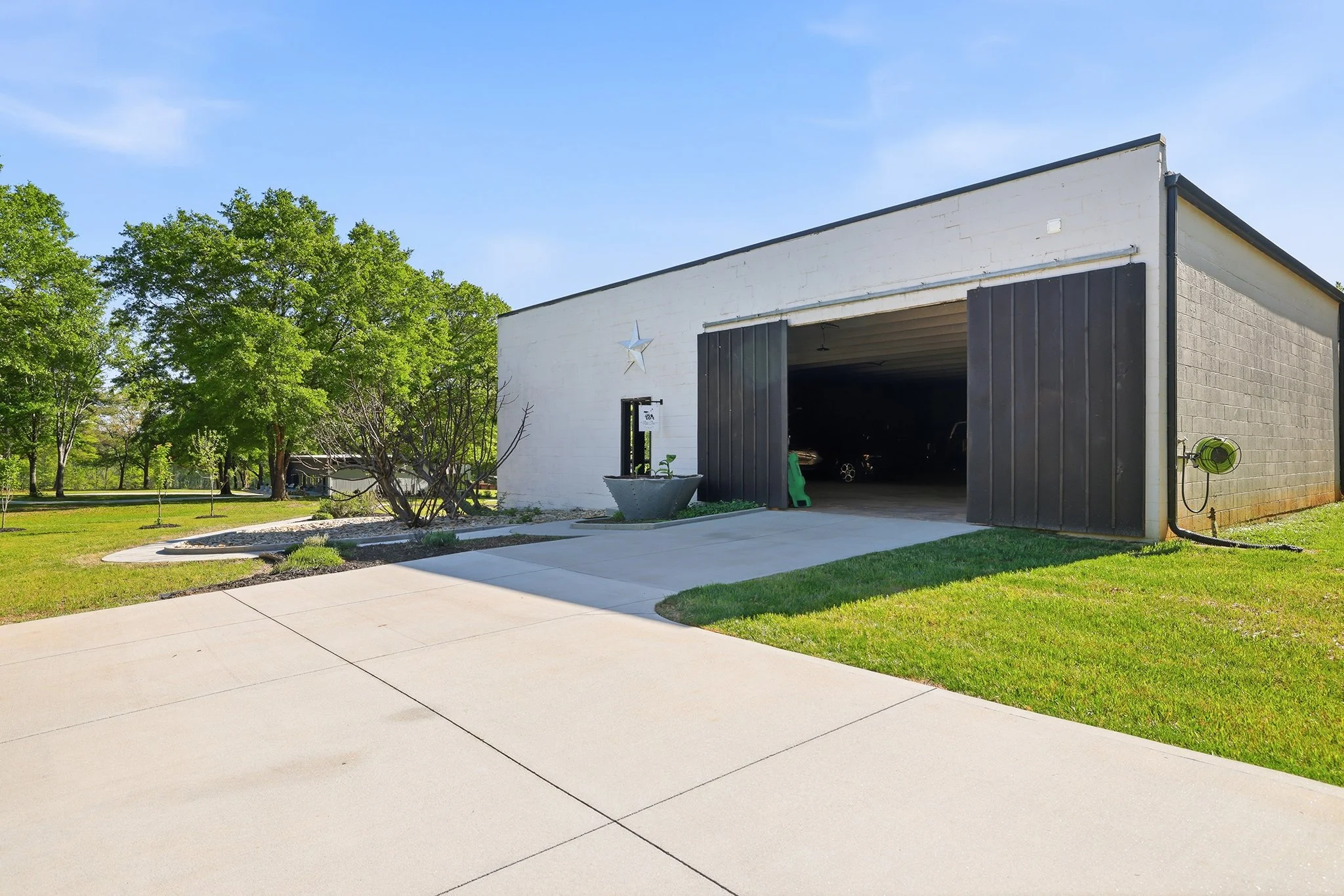 The 6-inch reinforced concrete driveway combines beauty and strength as it leads to the striking 12-foot-tall barn doors