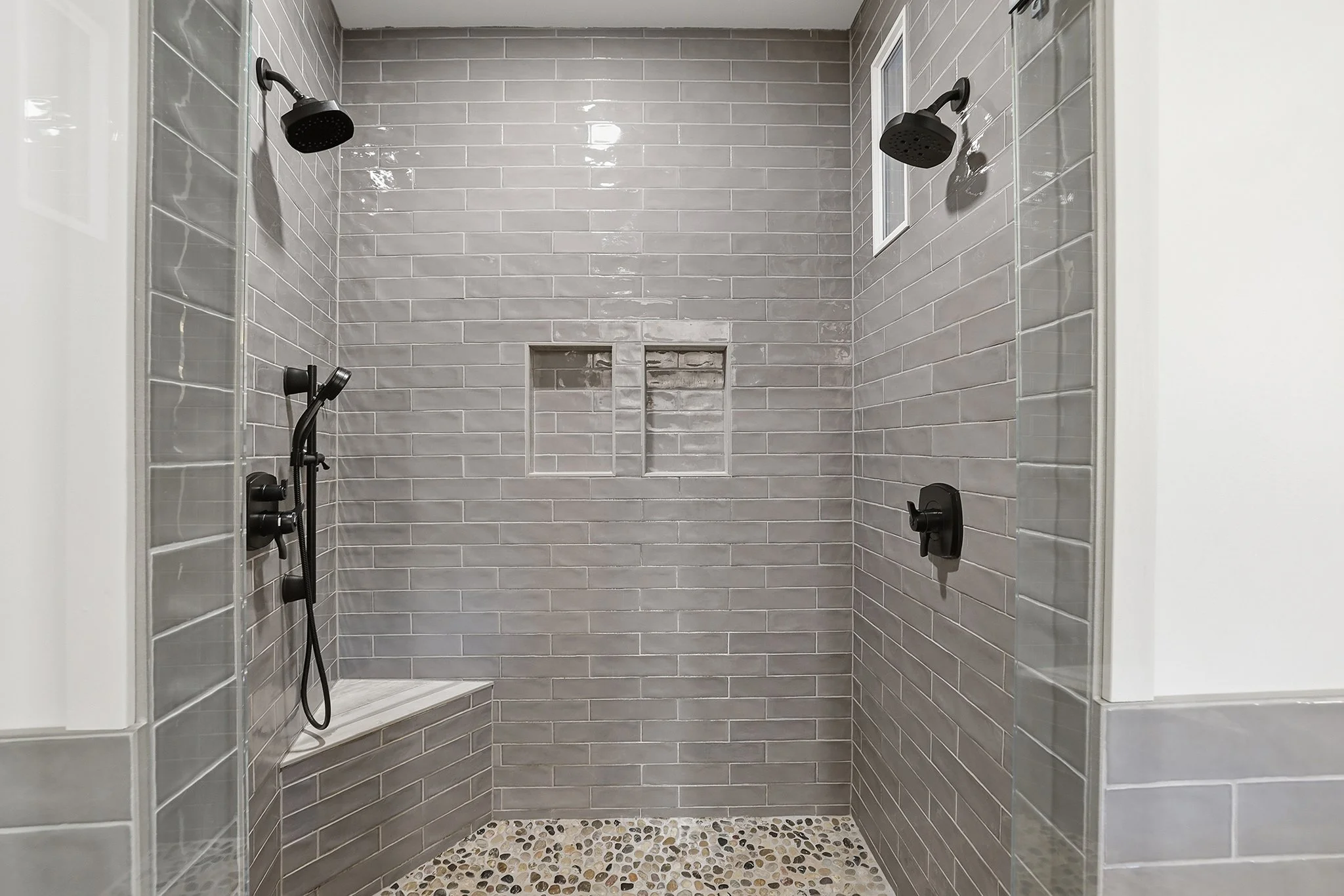 Relax in the dual shower with river rock floor and distressed subway tile