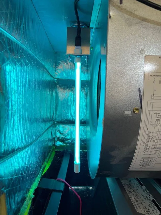A close-up of a UV-C sterilization lamp attached inside an industrial or laboratory equipment, with metallic interior panels and electrical wiring visible.