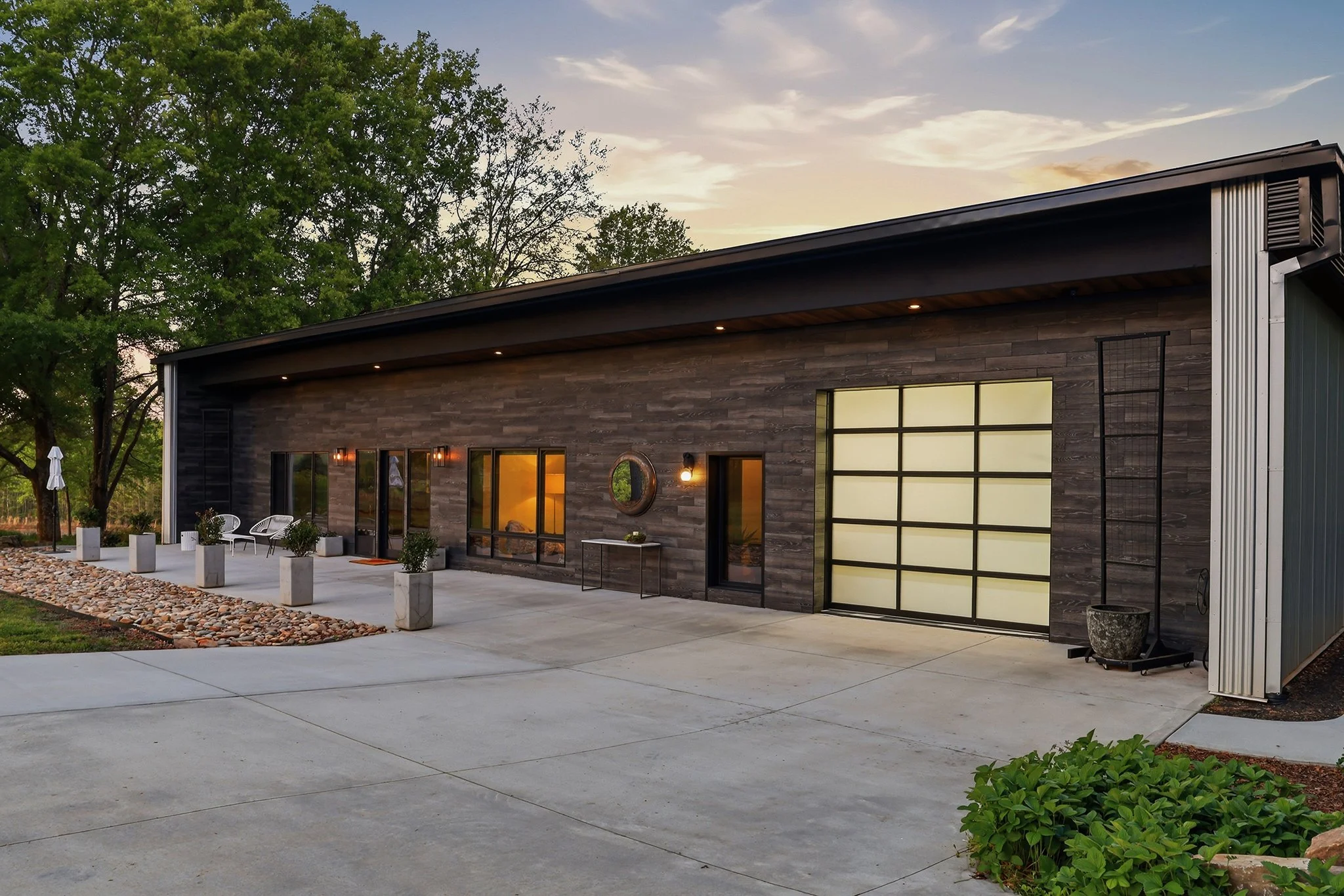 Driveway entrance leading to the modern grid garage door
