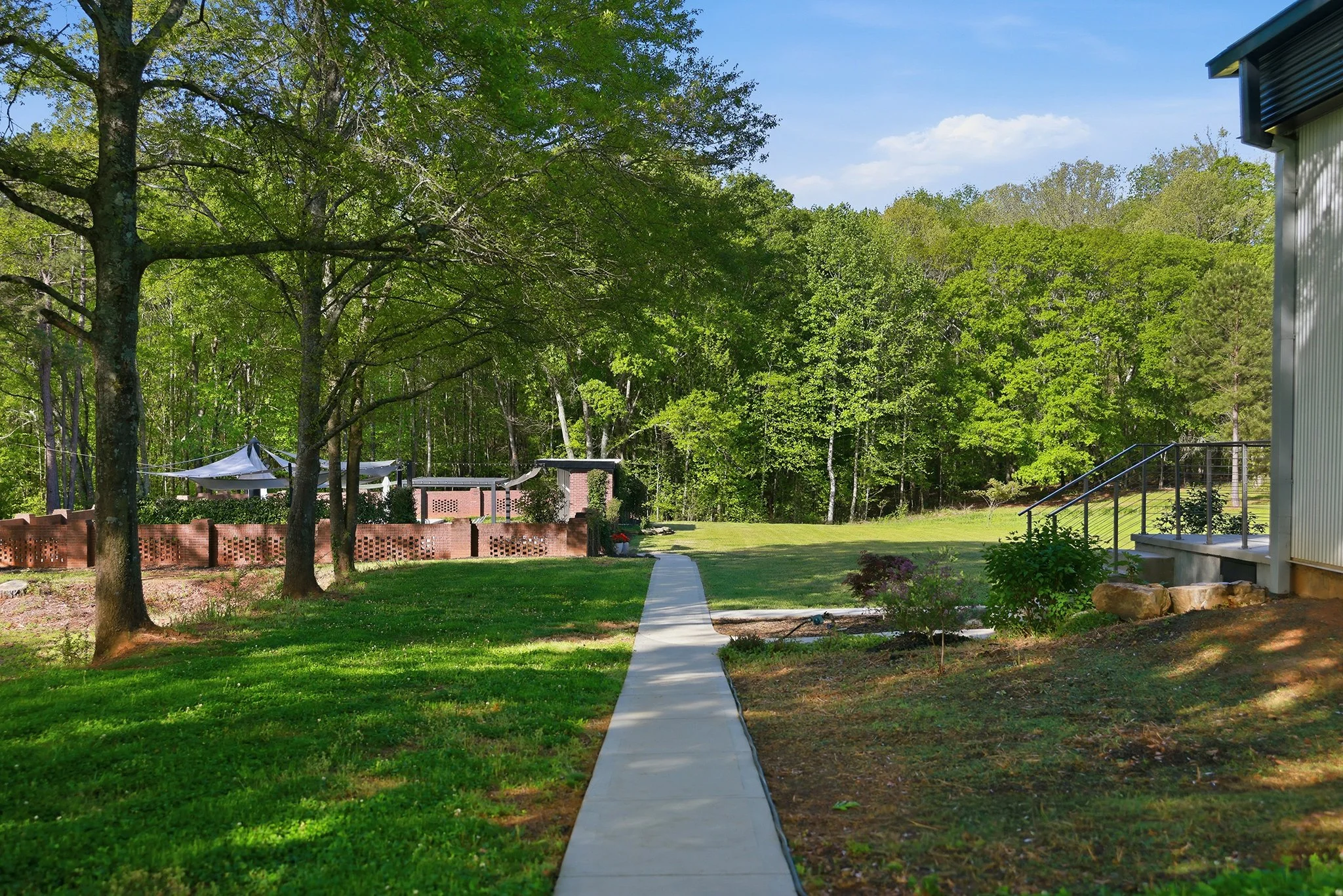 Sidewalks connect the entire property, this is an inviting view of the path to the pool next to a clover meadow
