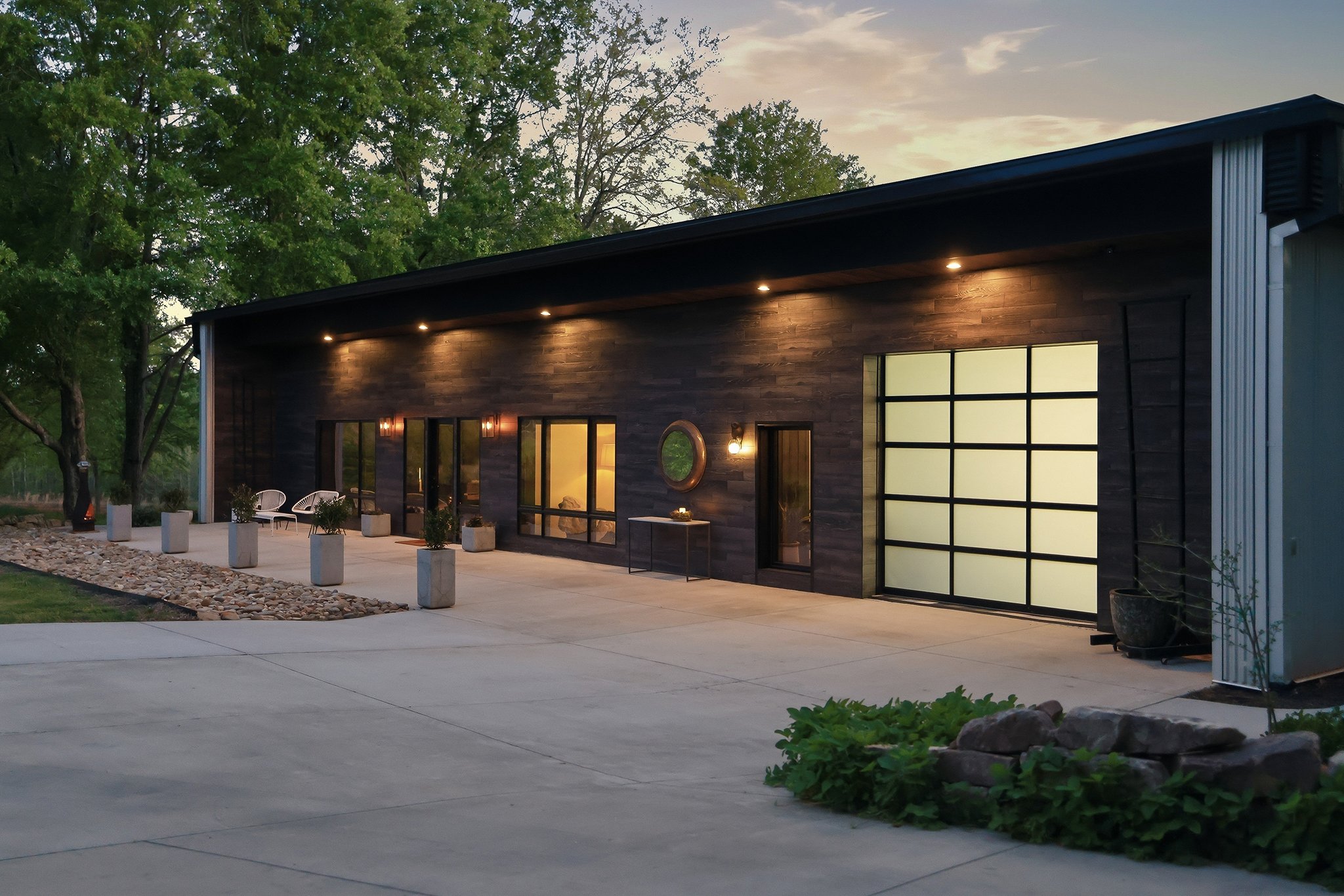 Twilight view of the house's front with the garage light illuminated