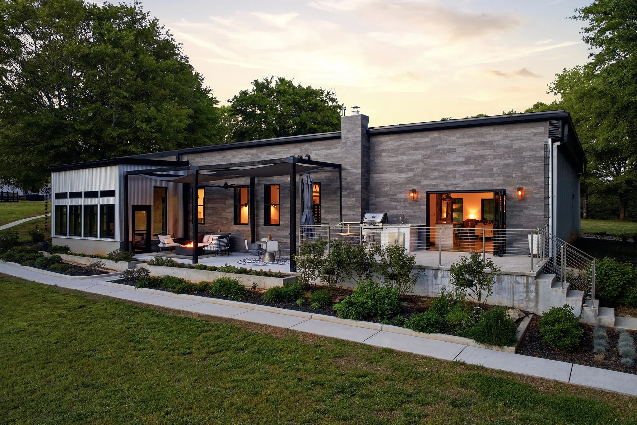 Soft, lovely, twilight view of the back of the home with raised flower beds 