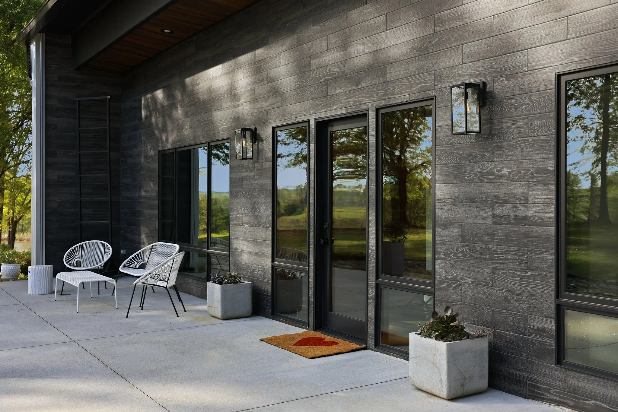 Front entrance with patio seating and classic Edison bulb modern sconces