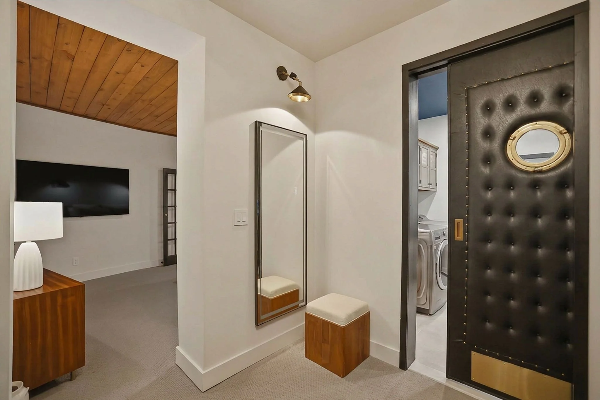 Get dressed in style with the full-length lighted wardrobe mirror; the leather-tufted pocket door leads to the laundry