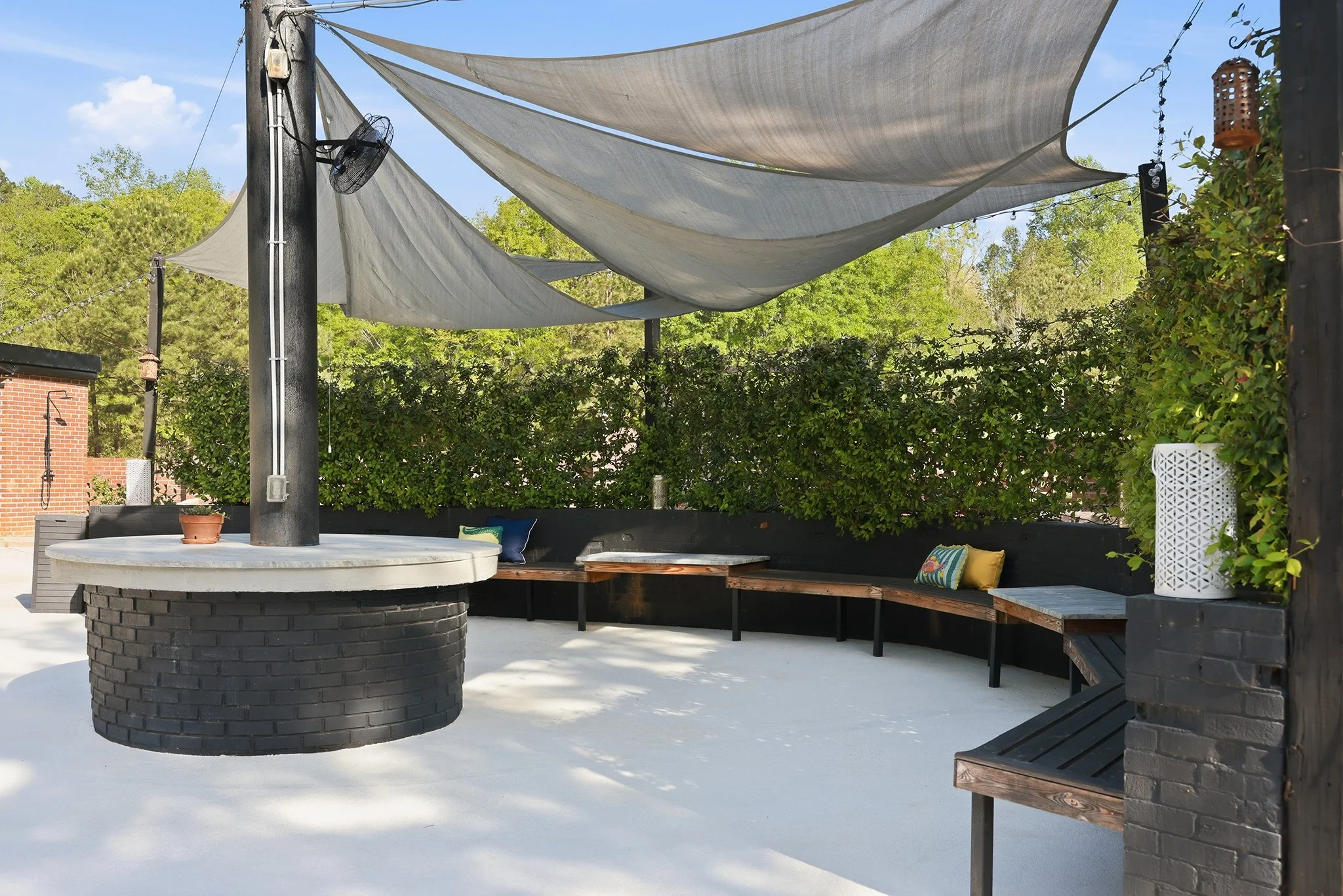 The custom cedar benches can easily seat 25 of your guests — use the round granite island to host cocktails and hors d’oeuvres