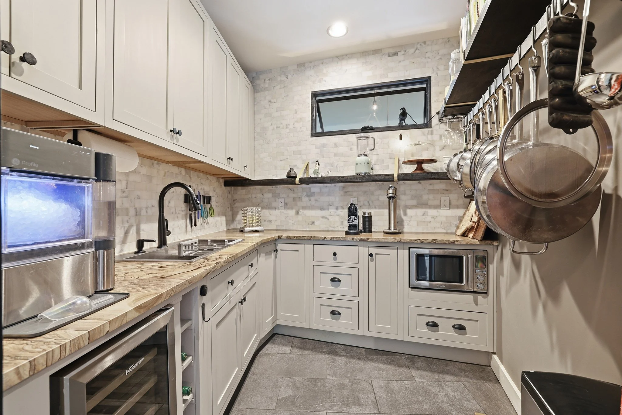 Butler’s pantry with ice maker, wine fridge, and prep area is perfect for entertaining