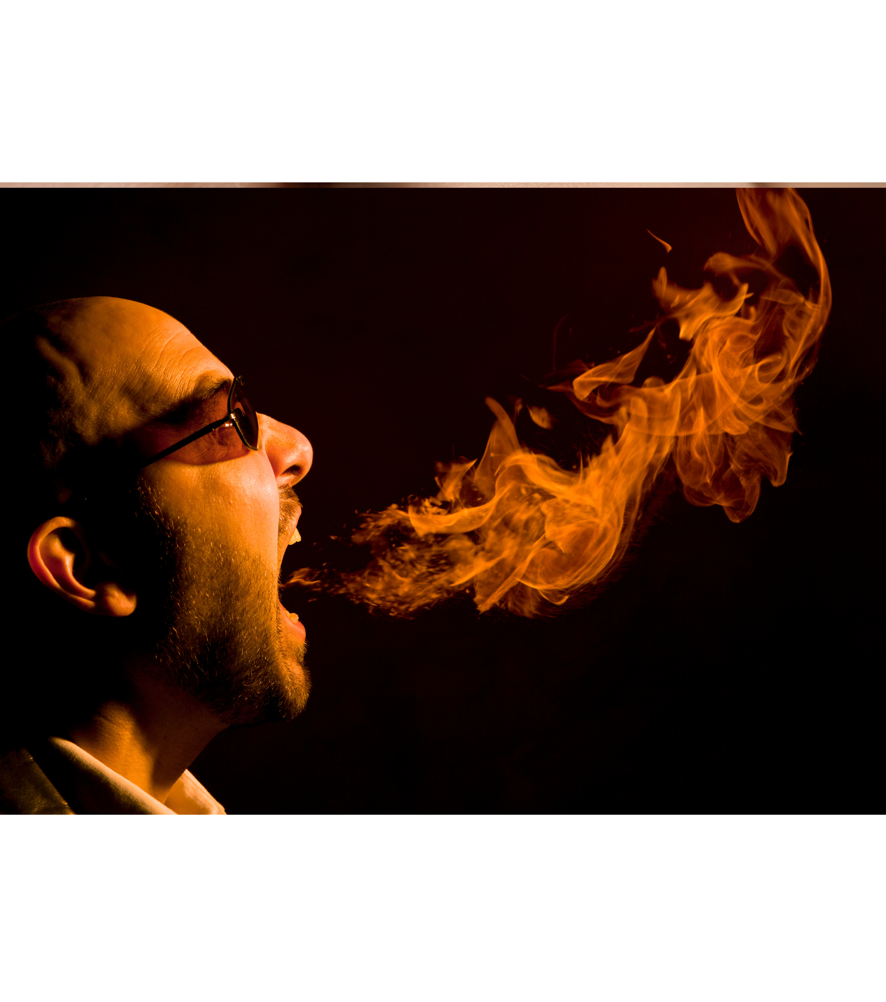 Homem usando óculos soltando fogo pela boca em um fundo preto