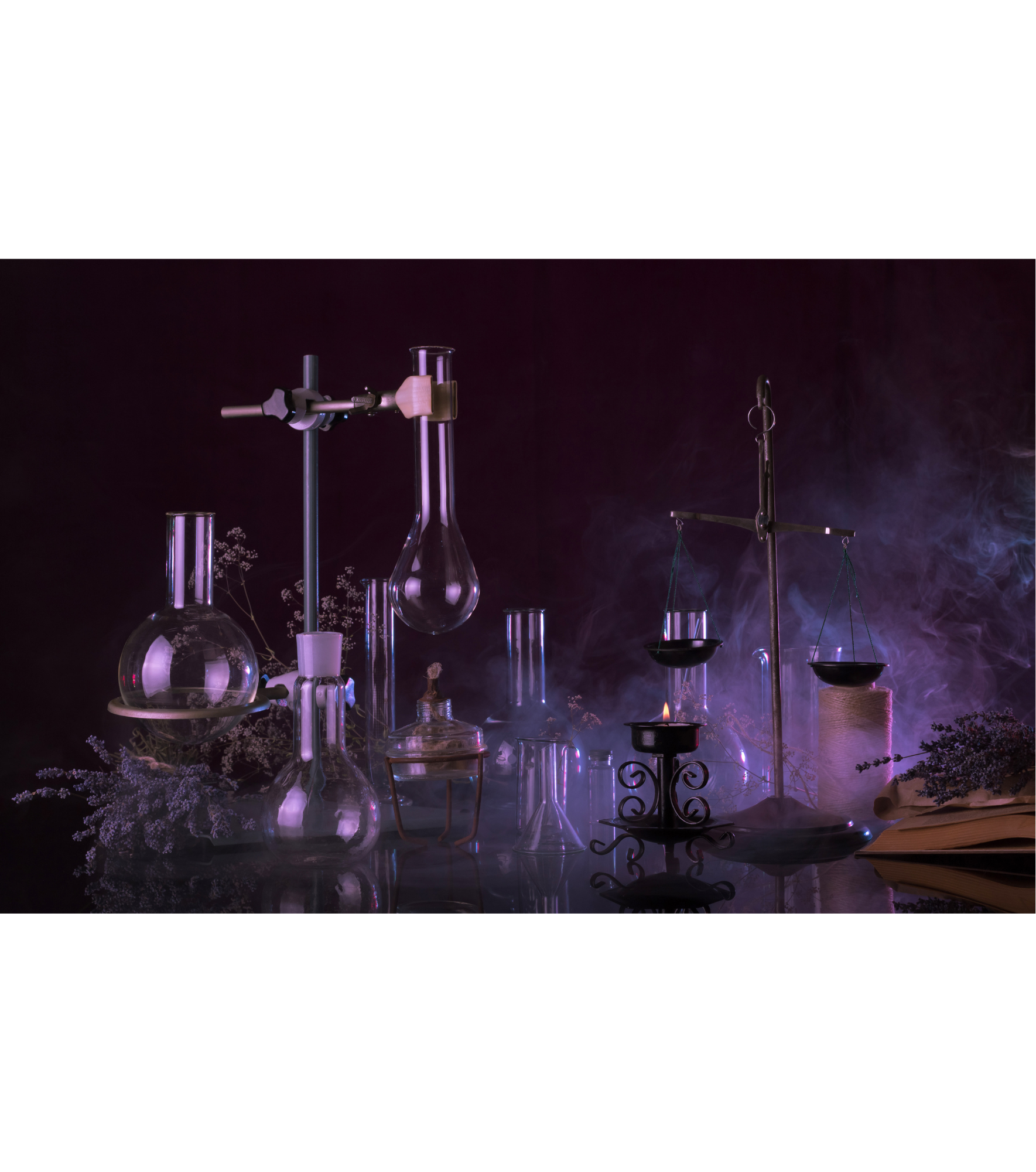 Vários itens de laboratório, como frascos, béqueres, tubos de ensaio e balança de precisão, em um ambiente com iluminação roxa e fumaça, criando uma atmosfera misteriosa e científica.