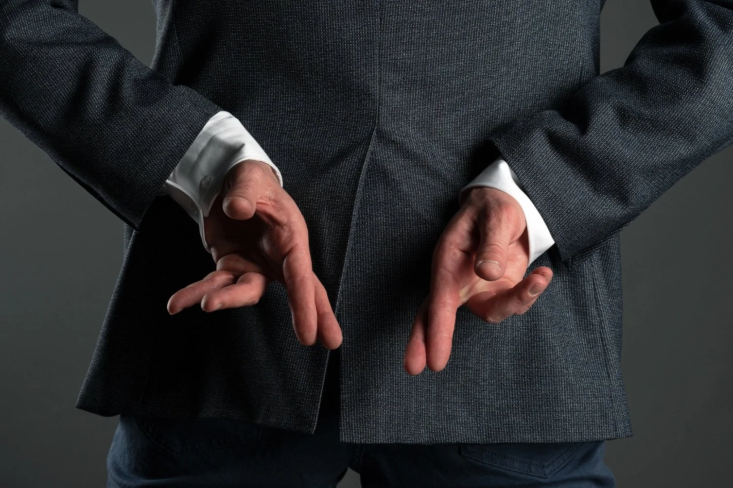 Pessoa de terno fazendo sinal de three finger gesture.