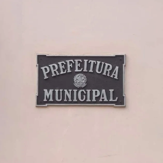 Placa indicando 'Prefeitura Municipal' fixada em uma parede