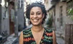 Mulher sorridente com cabelo cacheado em uma rua urbana