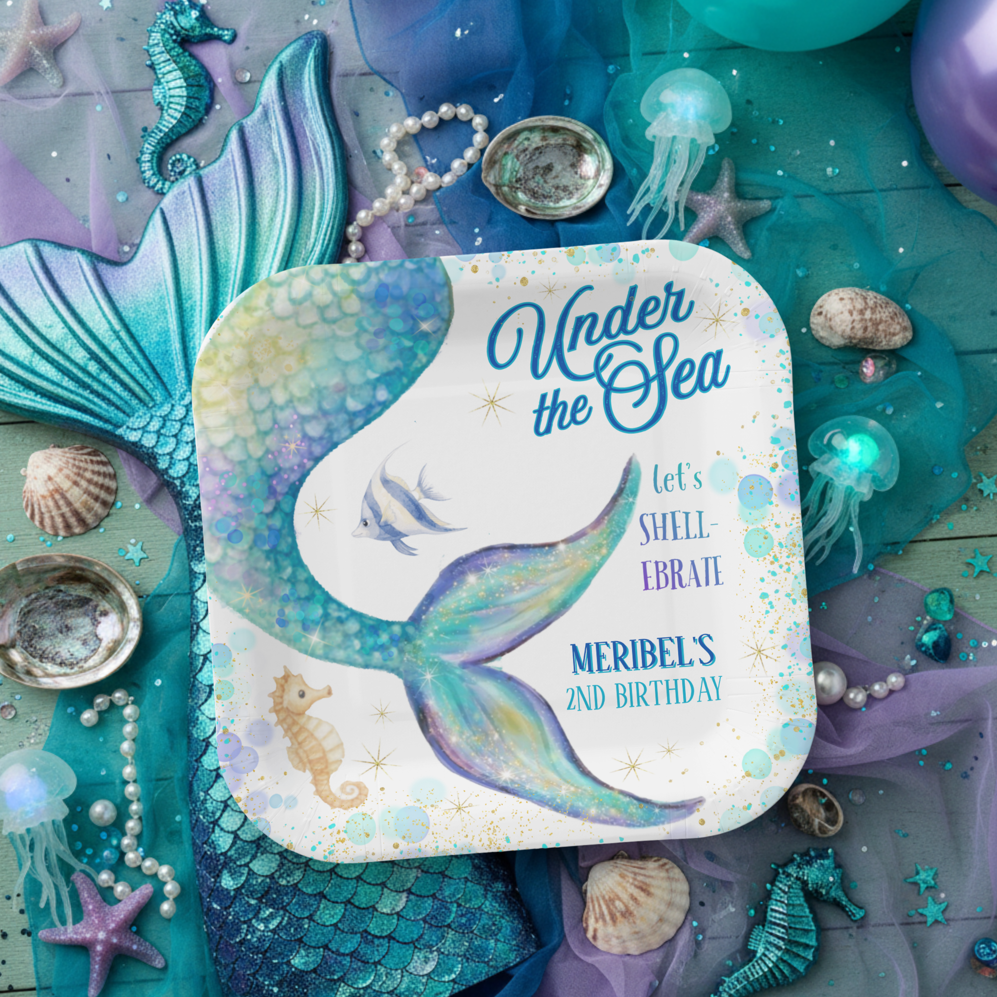 Mermaid Under the Sea birthday paper plates featuring a dreamy watercolor mermaid tail in soft teal, sea foam, and purple with floating bubbles, gold star accents, and cute ocean details like a seahorse and tropical fish. The coastal script adds extr
