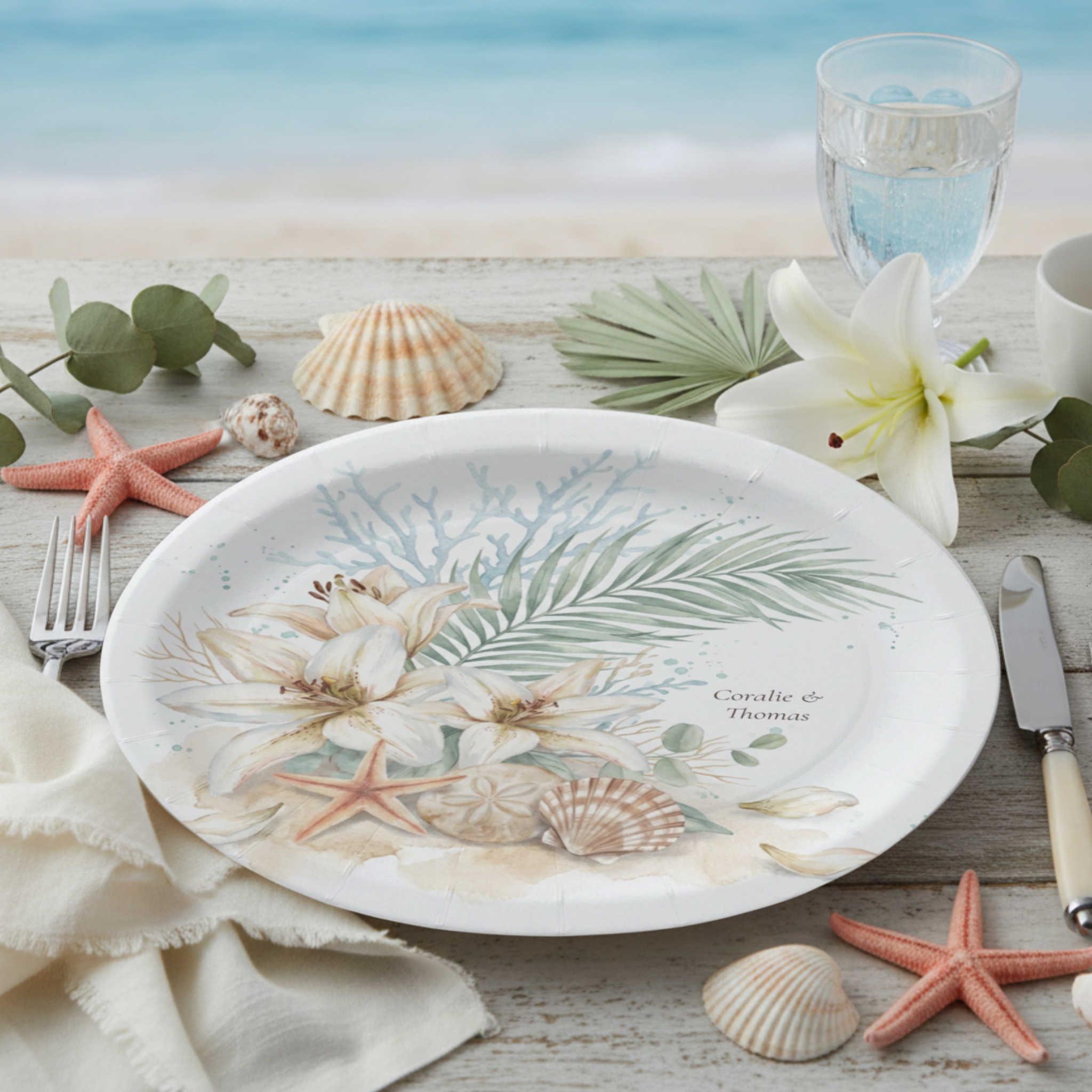 Tropical Boho Beach wedding paper plates featuring a romantic watercolor arrangement of white Oriental lilies, seashells, coral accents, palm fronds, and eucalyptus leaves. Designed without the crest, this variation highlights the natural coastal flo